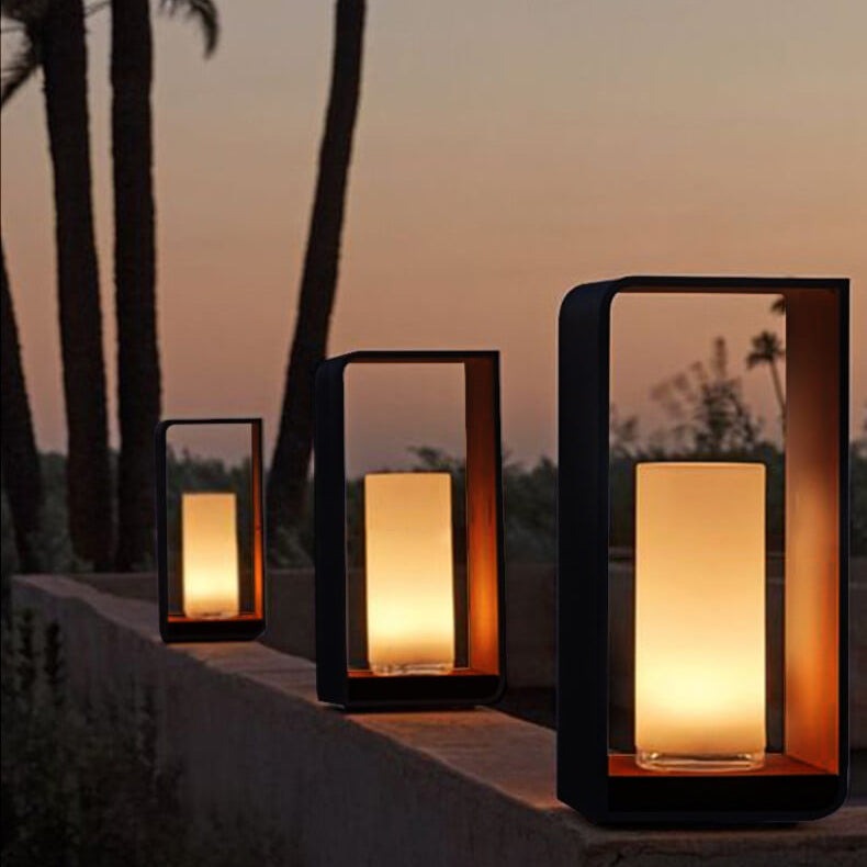 Square LED landscape light illuminating an outdoor patio at dusk