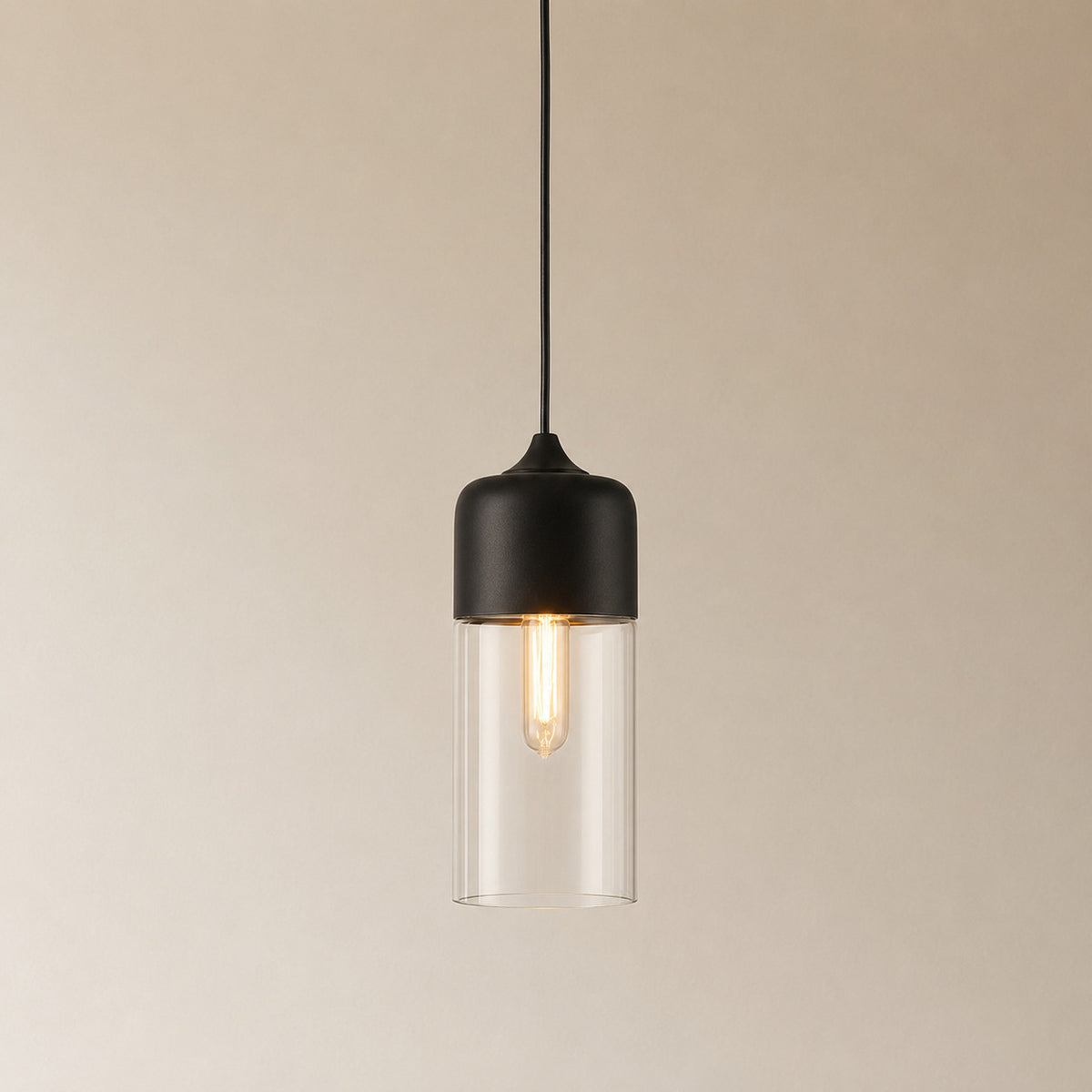 Alge glass pendant with a matte black cap and a clear glass shade, a tall narrow cylinder measuring 33 by 13 cm