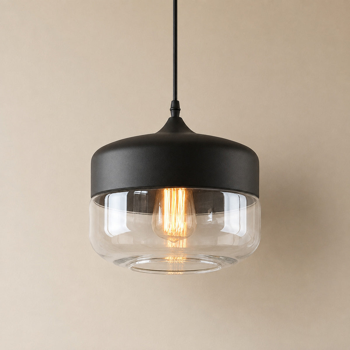 Alge glass pendant with a matte black cap and a clear glass shade, a wide shallow drum