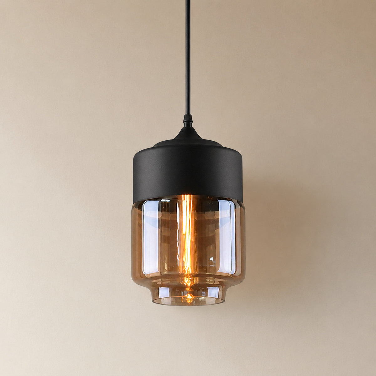 Alge glass pendant with a matte black cap and an amber glass shade, a shorter, wider upright cylinder measuring 28 by 18 cm