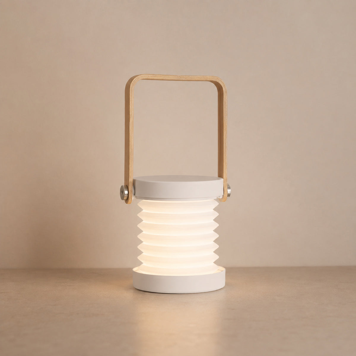 Alva collapsible portable lantern in white, pulled open, with a bamboo swing handle