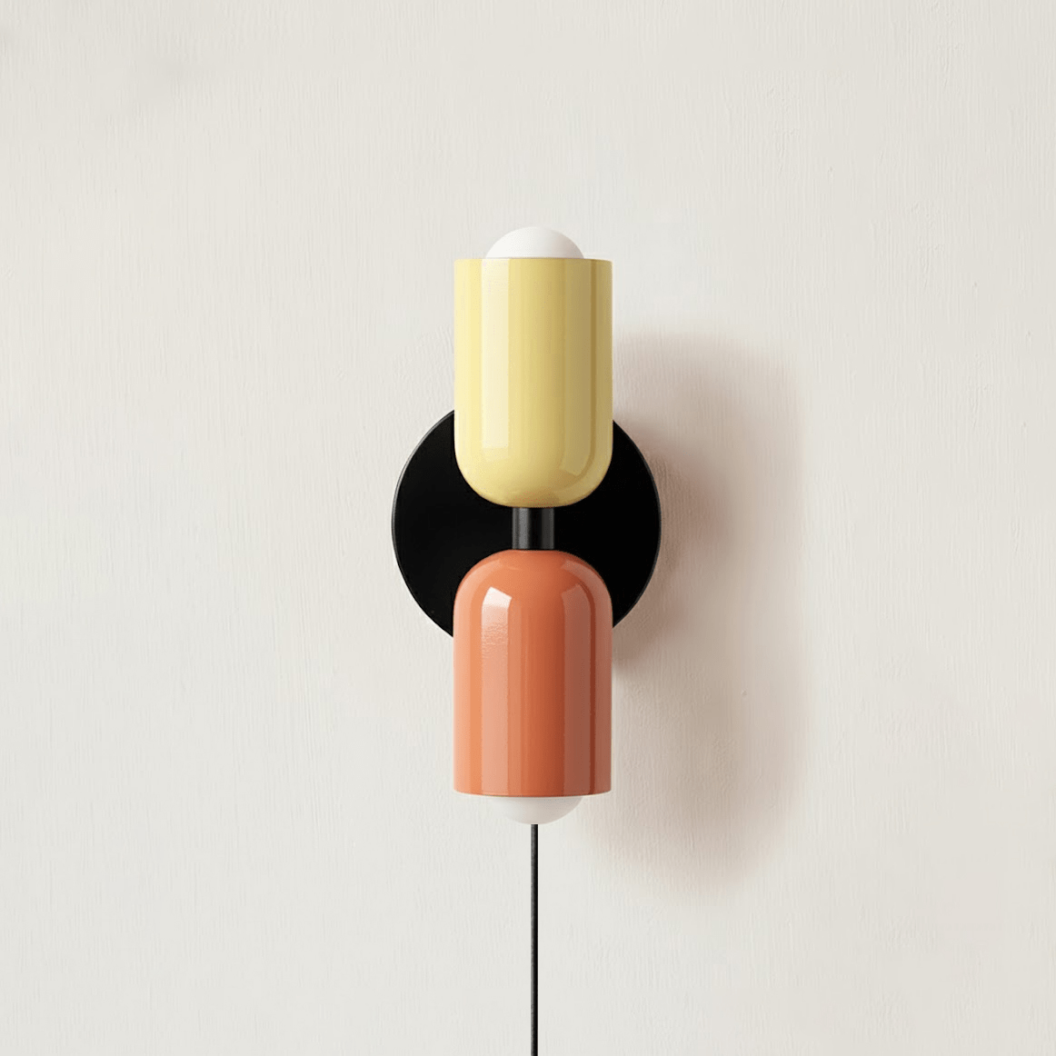 Alvor wall sconce with beige upper and pink lower painted metal shades on a plaster wall