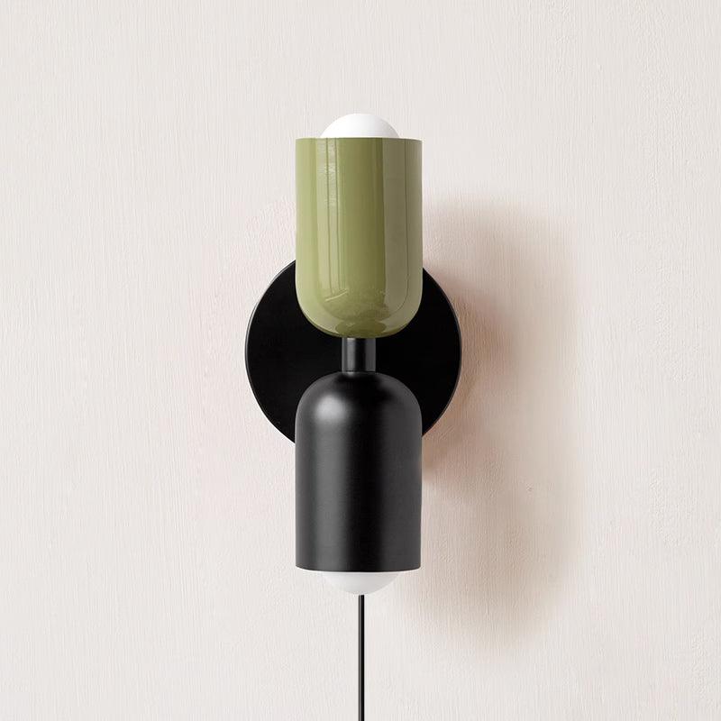 Alvor wall sconce with green upper and black lower painted metal shades on a plaster wall