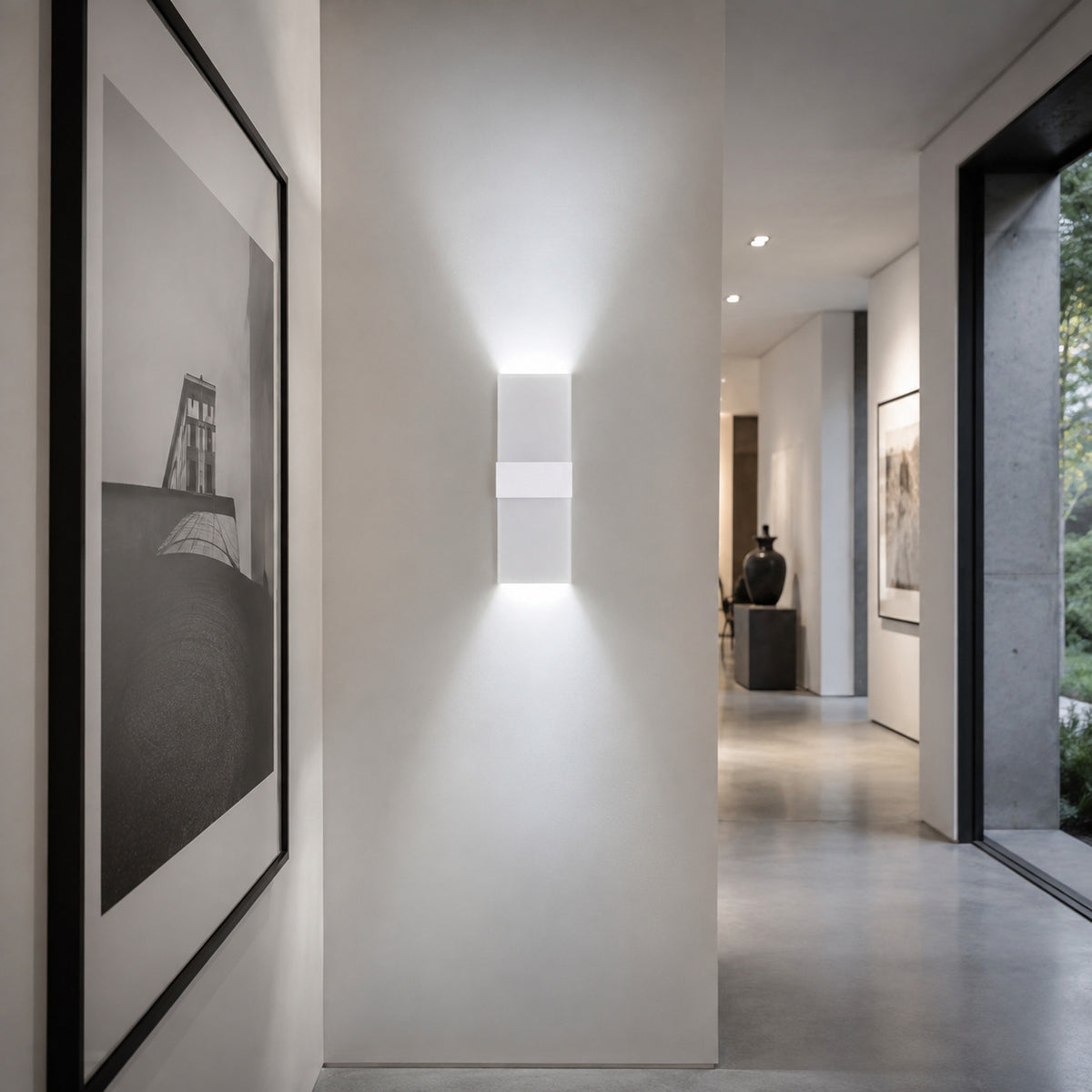Anços sconce in white with cool white light in a gallery hallway
