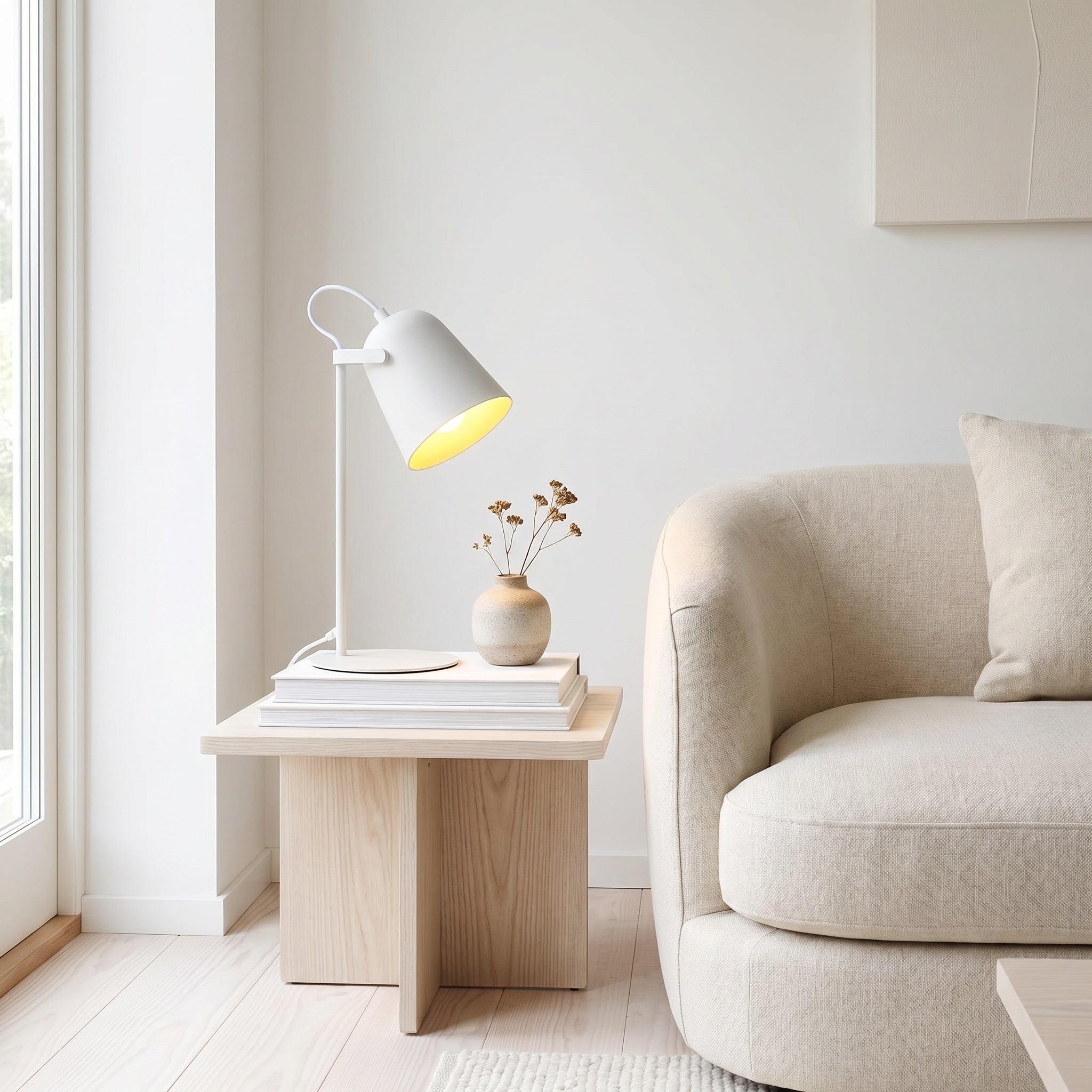 Iron bucket table lamp glowing on a desk in a styled room.