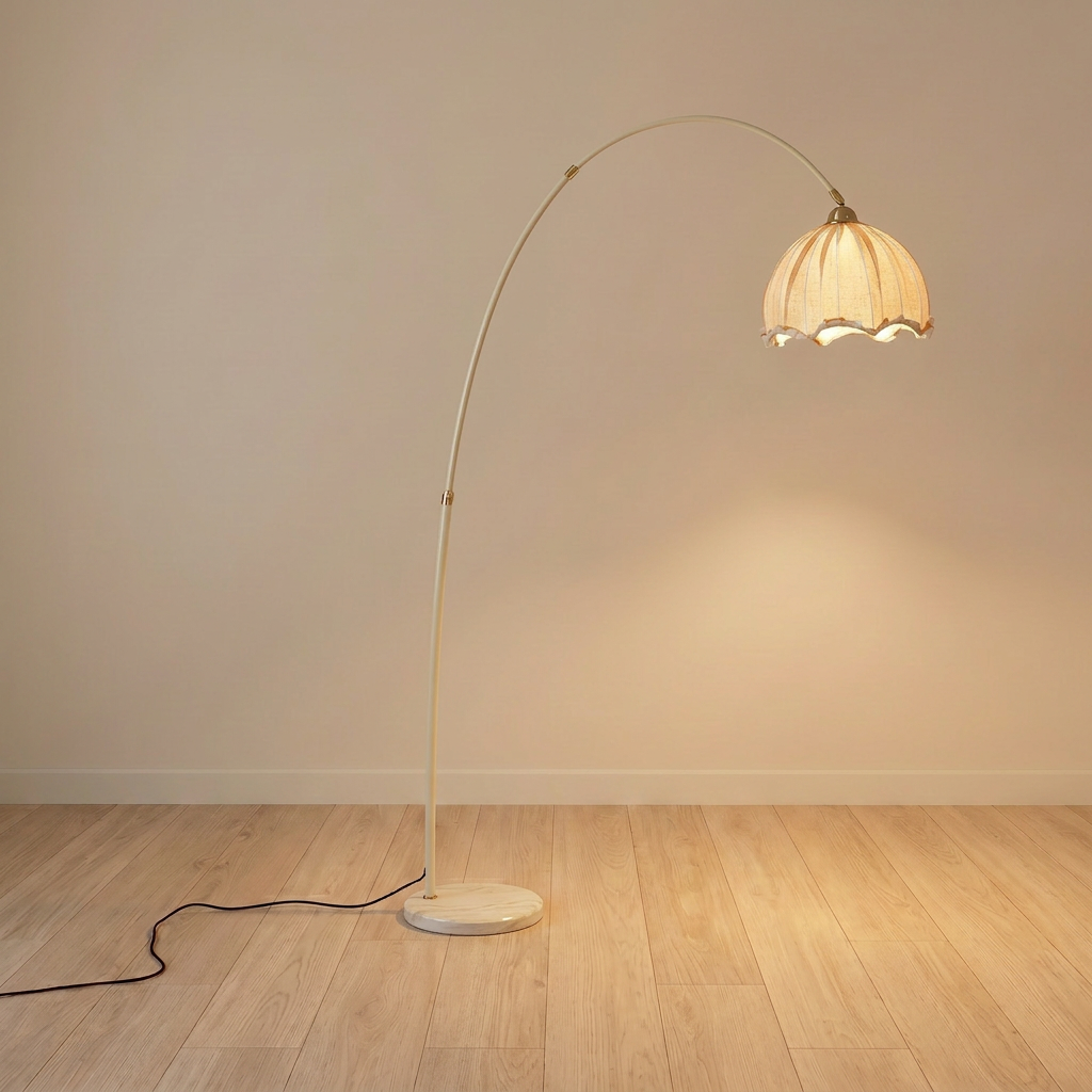 Arc floor lamp with beige stem and white scalloped fabric shade on a cream marble base, product shot.