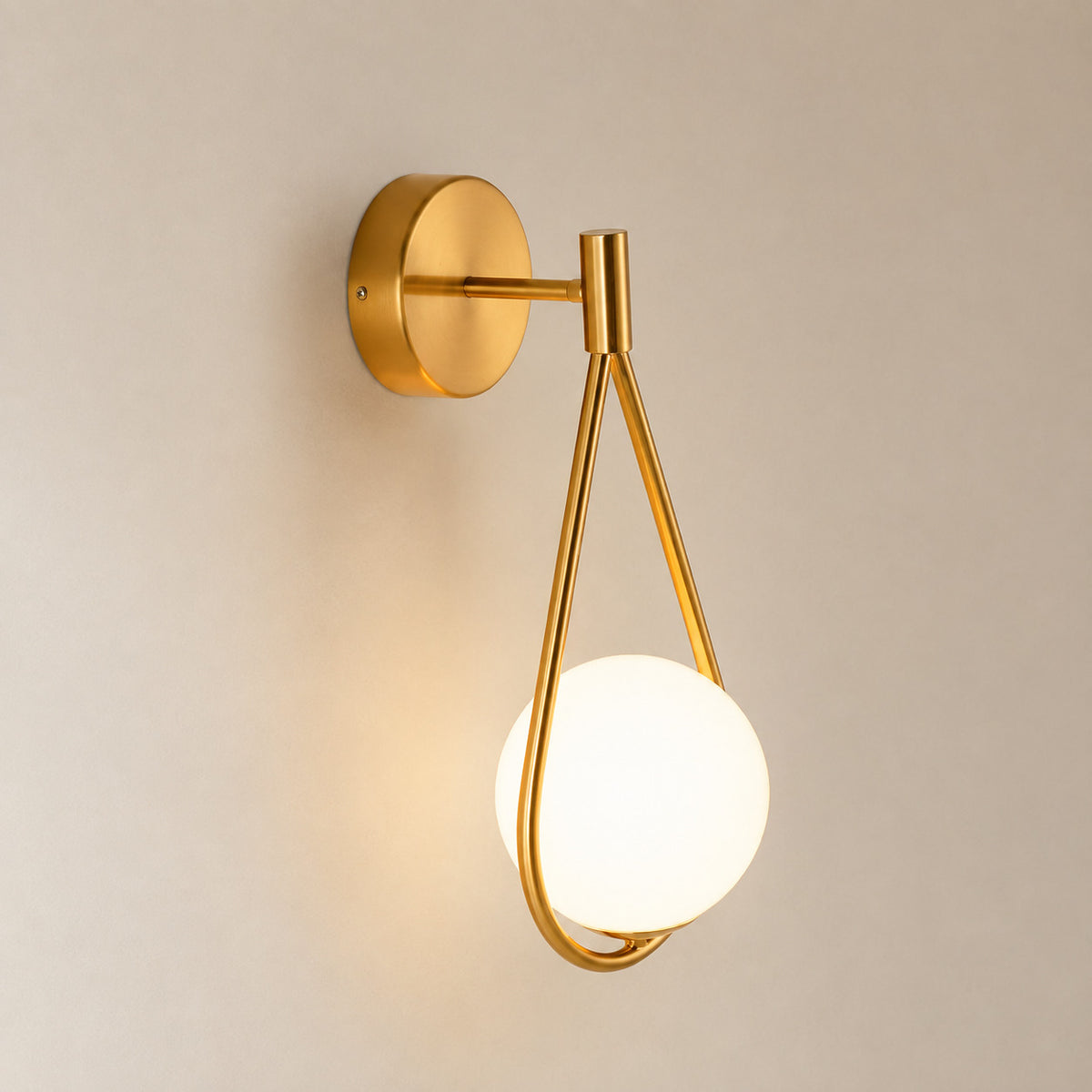Celorico loop wall sconce with a polished brass teardrop and an opal white globe
