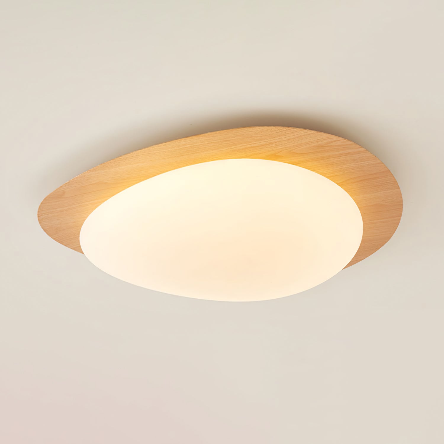 Ericeira pebble form flush mount ceiling light in natural wood grain finish, isolated product view