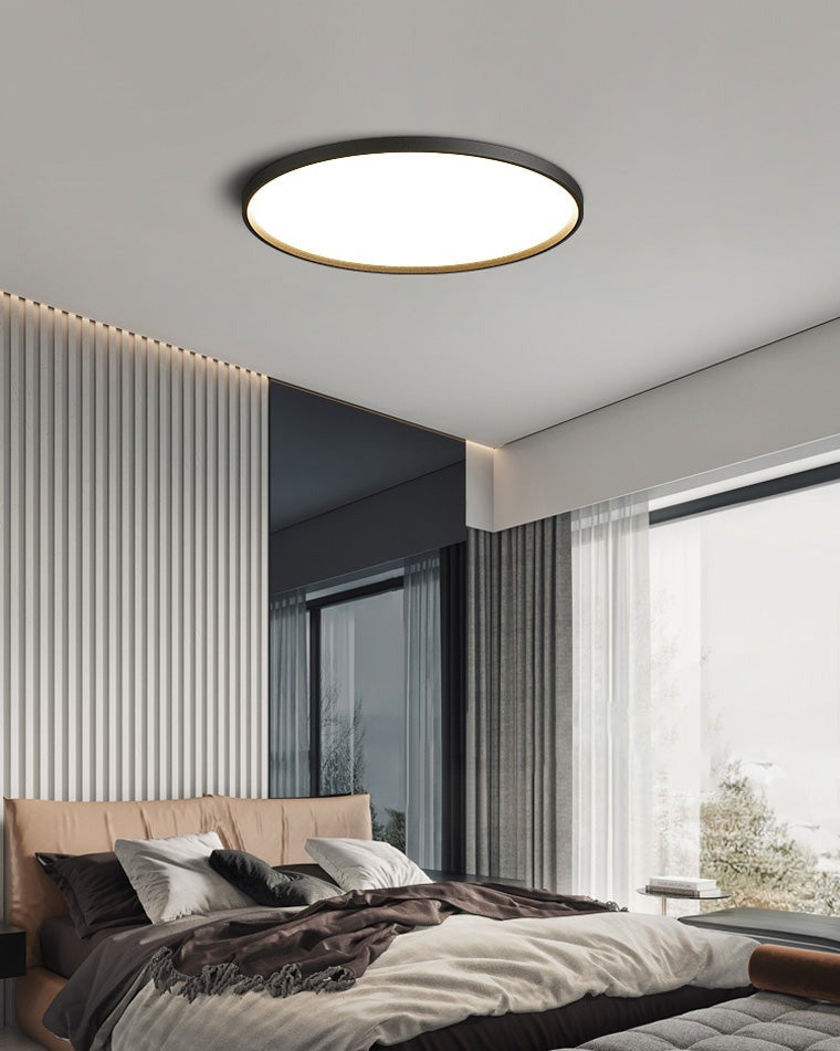 Estorãos flat round flush mount ceiling light, in a bedroom, against a slatted wood wall.