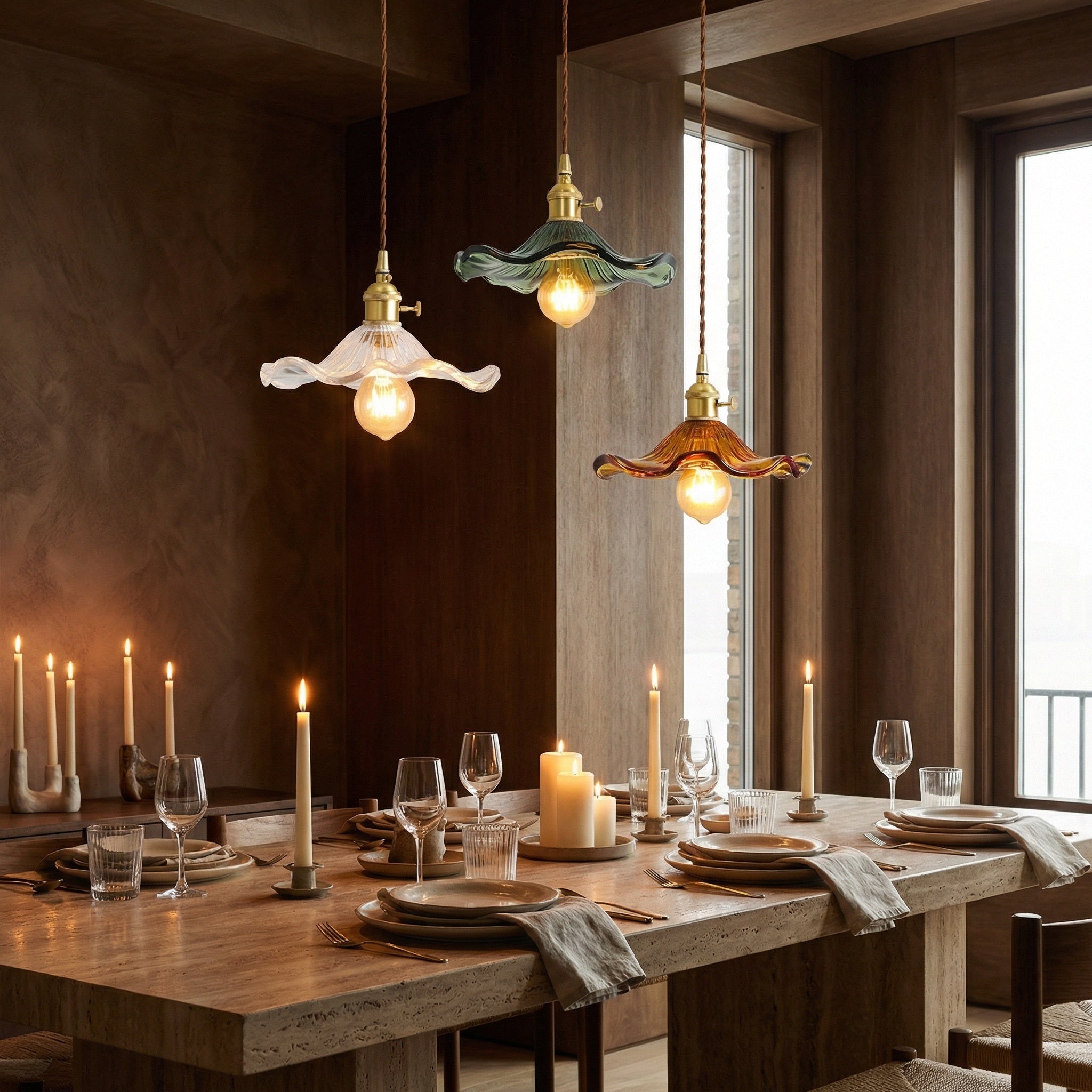 Ferragudo glass flower pendant lights in clear, green and brown over a candlelit dining table