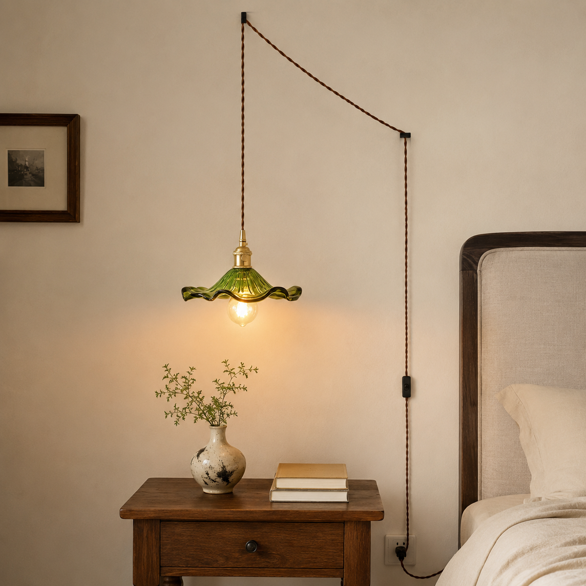 Ferragudo green glass pendant on a swag cord over a bedside table, plugged into a wall outlet.