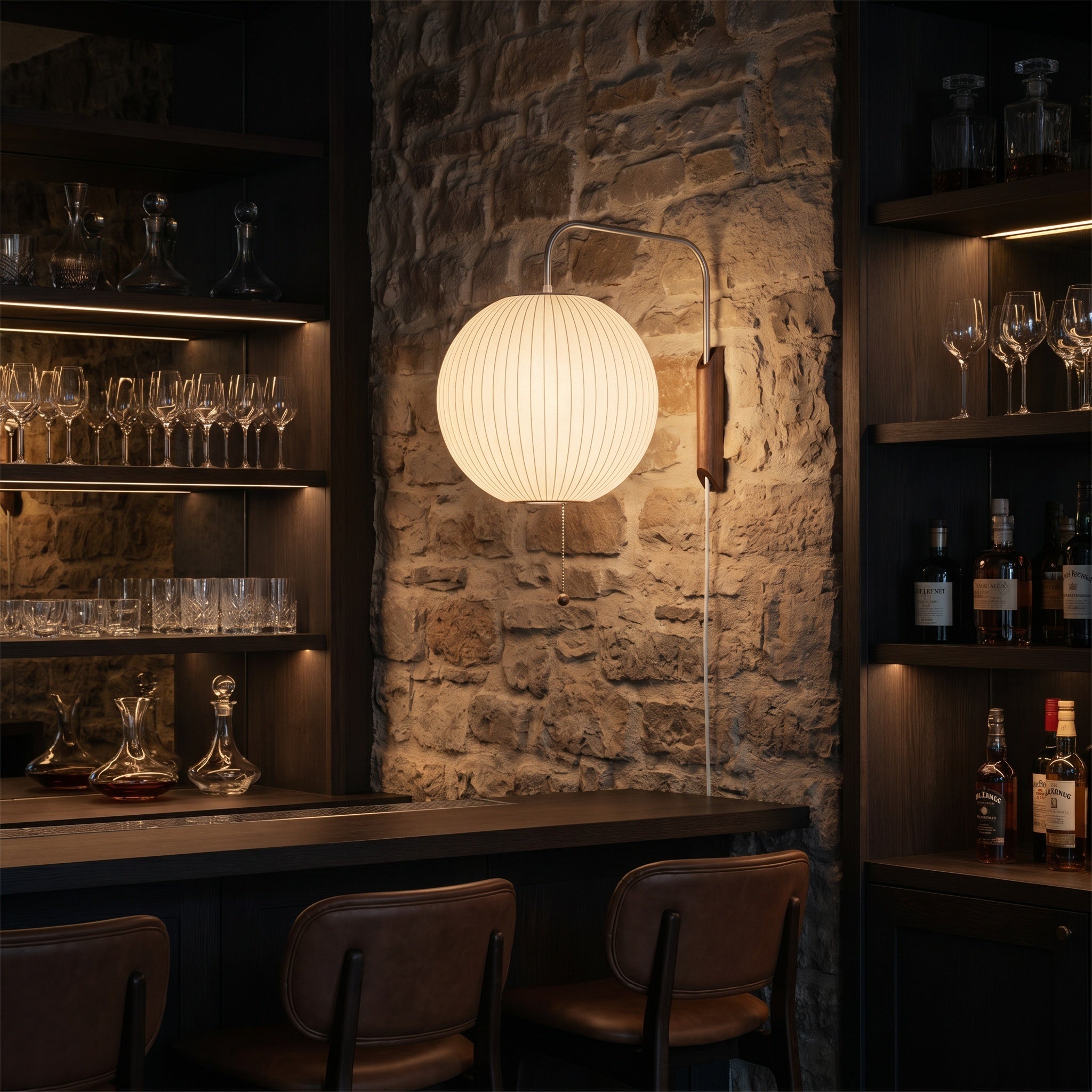 Mirandela globe wall sconce mounted beside a reading chair in a living room