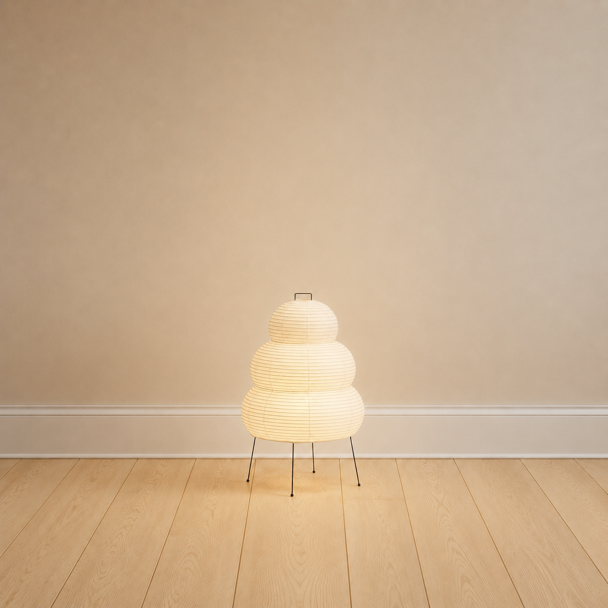 Mulberry paper table lamp, stacked round form, on a black metal tripod, product shot.
