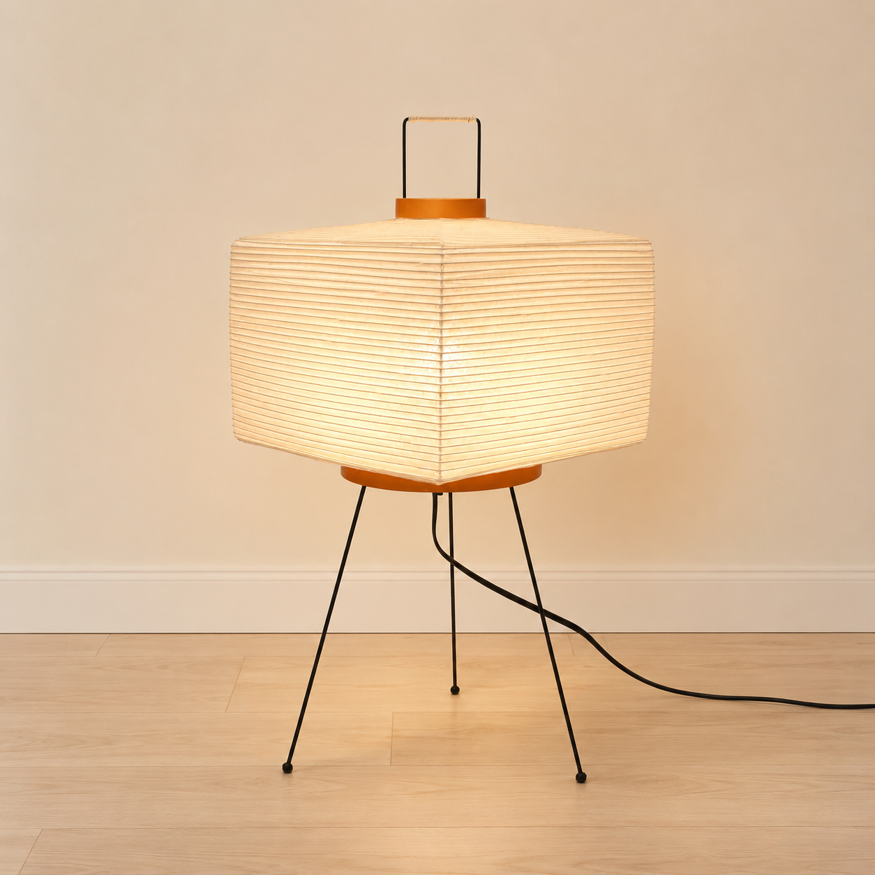 Mulberry paper table lamp, taller faceted form, on a black metal tripod.