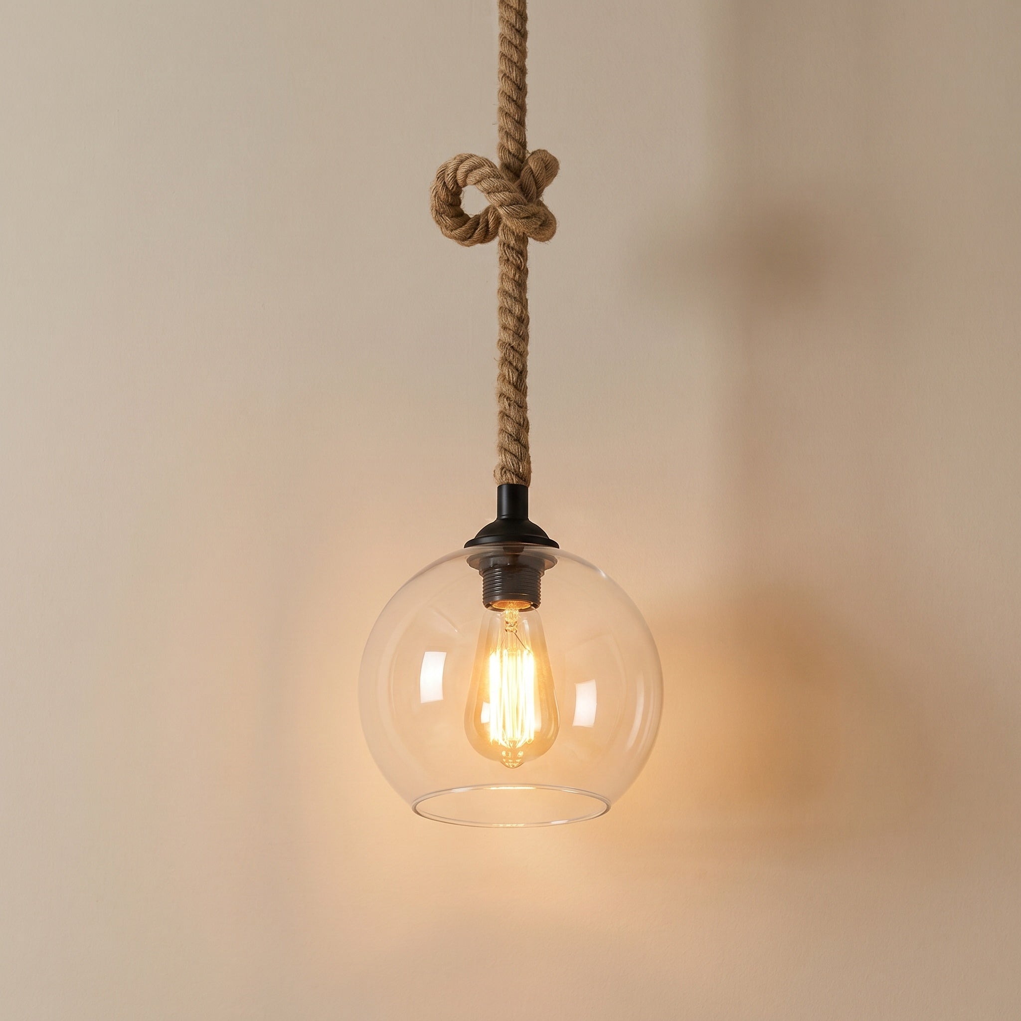 Peniche hemp rope glass globe pendant light shown front on against a plain studio backdrop