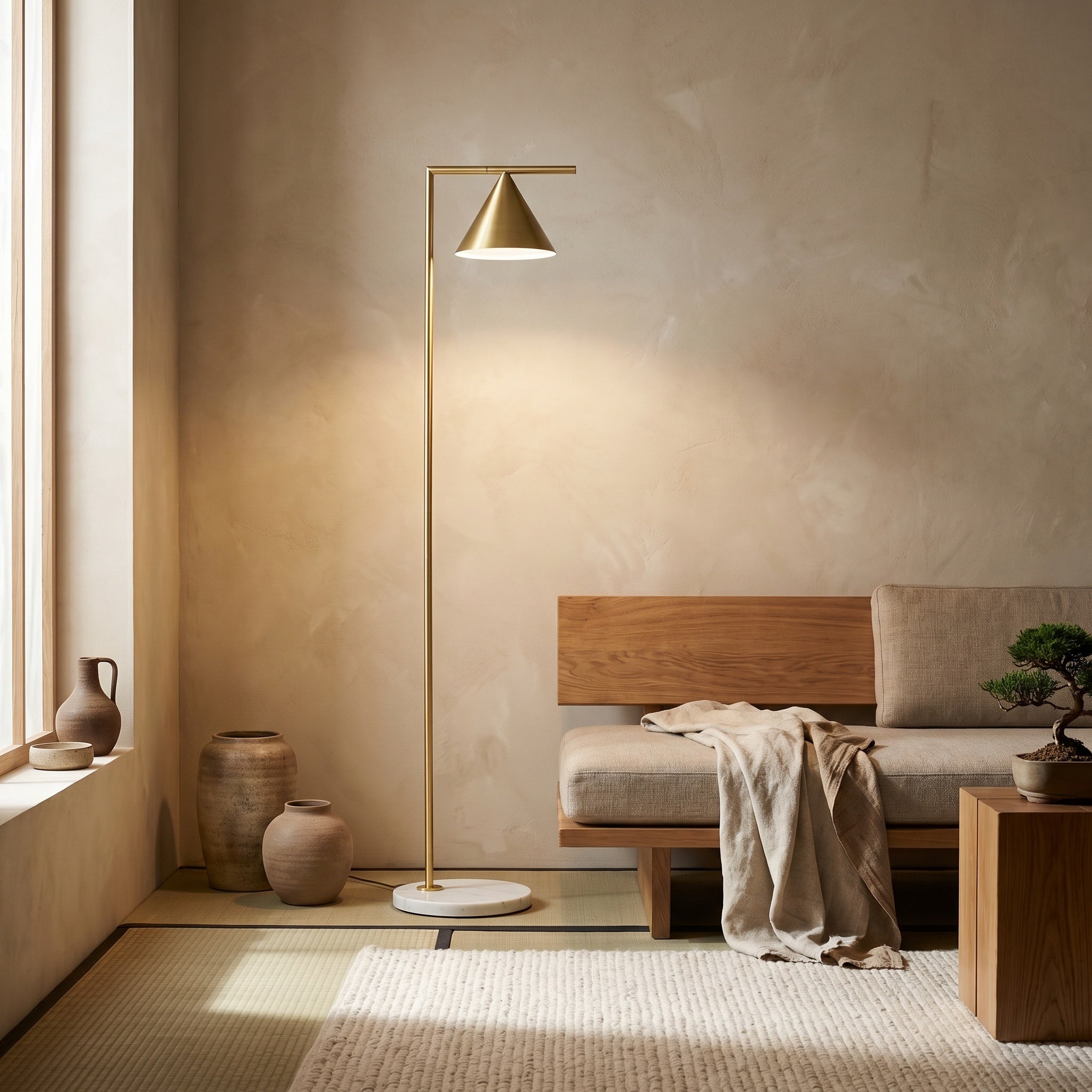 Copper cone floor lamp in an earthy plaster-wall room with wooden bench and pots.