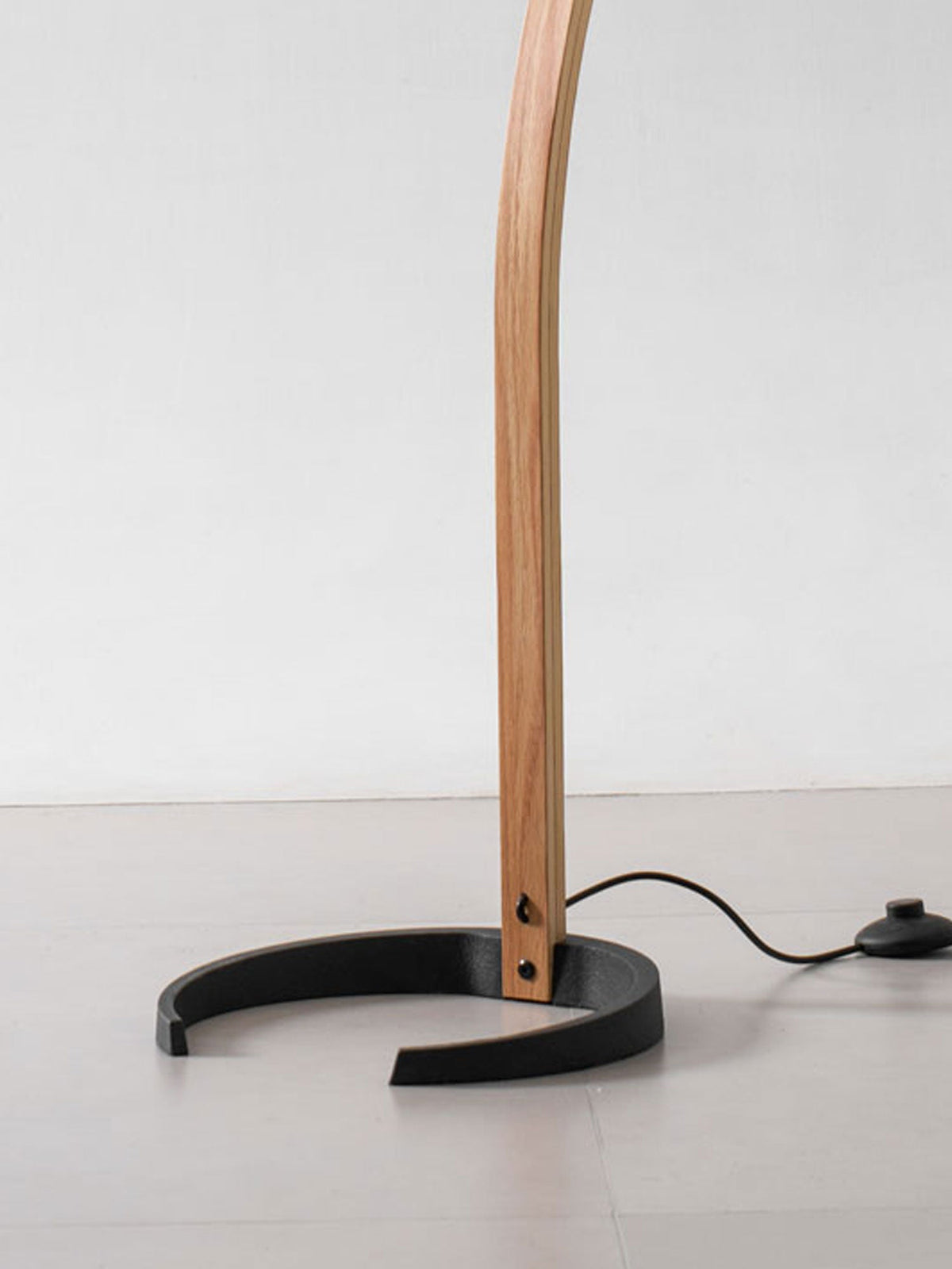 Crescent base, beech stem and inline foot switch of the Tomar floor lamp.