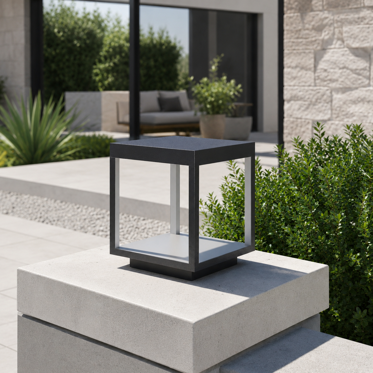 Alcabrichel square stainless steel post light on concrete pillar with stone wall and outdoor lounge area in daylight
