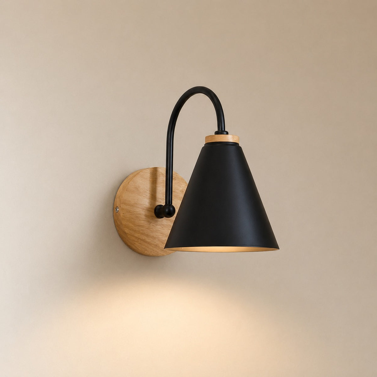 Alenquer wall sconce in black with solid wood backplate, lit warm on a beige wall