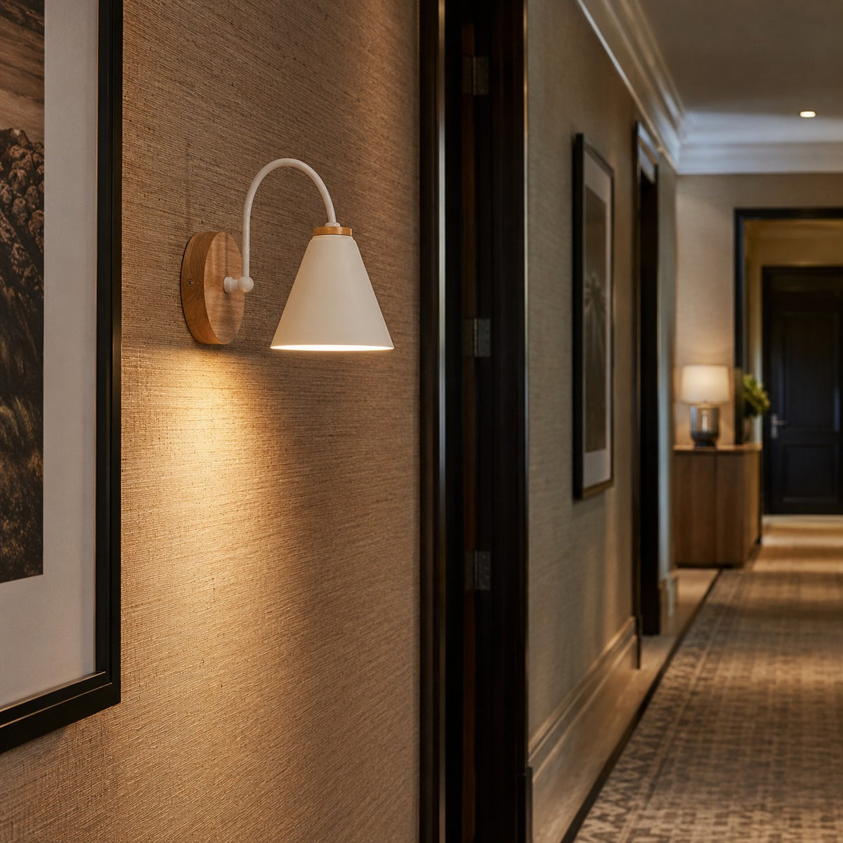 Alenquer wall sconce in white mounted in a corridor with framed art