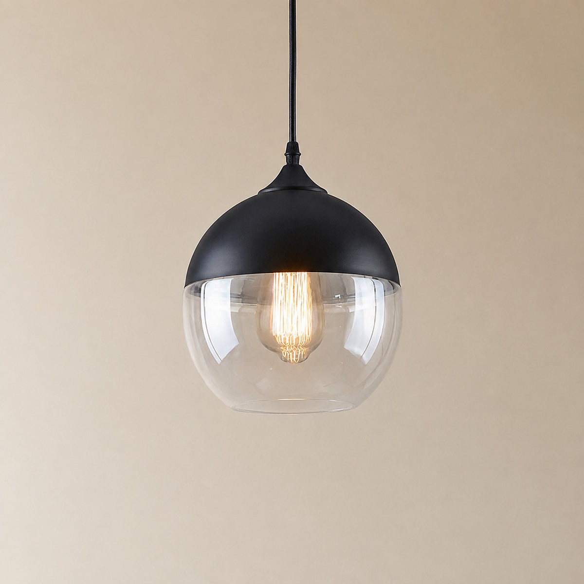 Alge glass pendant with a matte black cap and a clear glass shade, a rounded globe