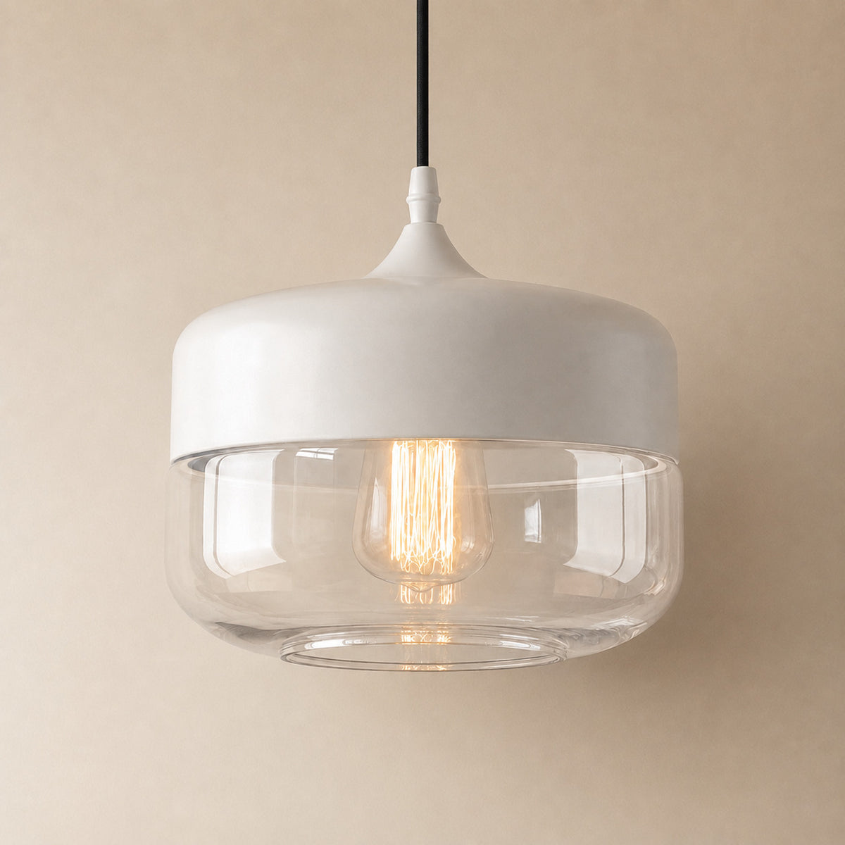 Alge glass pendant with a white cap and a clear glass shade, a wide shallow drum, wider than it is tall measuring 21 by 25 cm