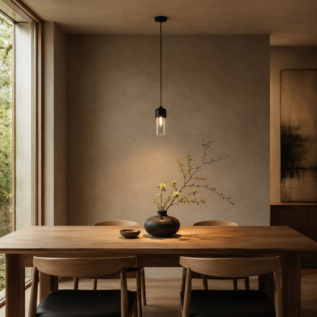 Alge pendant in black and clear, tall cylinder shape, above an oak table in a Japandi dining room