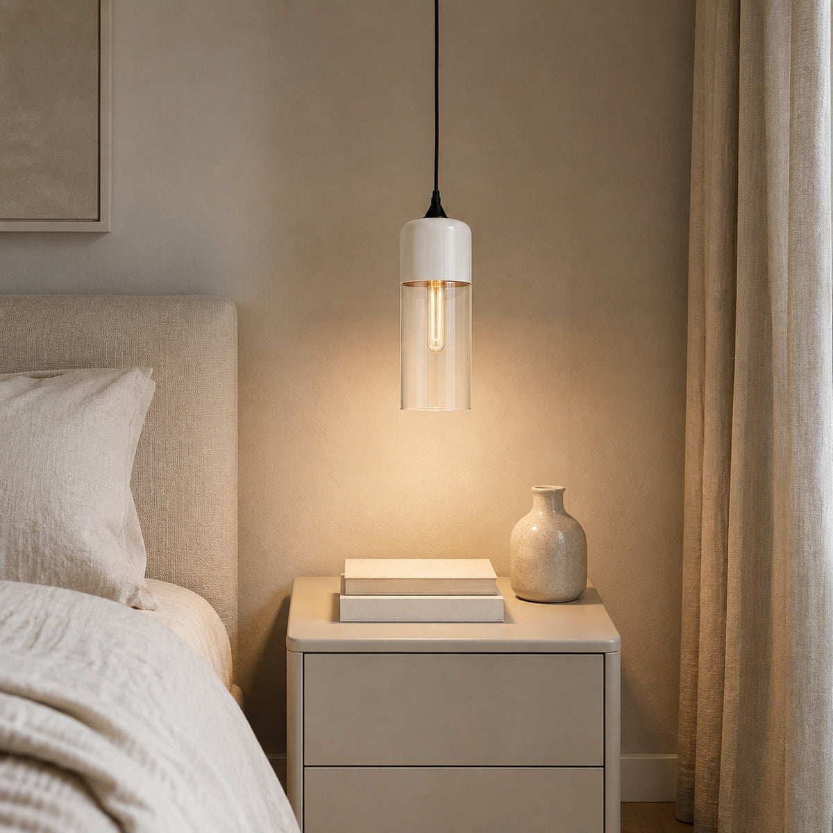 Alge pendant in white and clear, tall cylinder shape beside a bed in a quiet corner