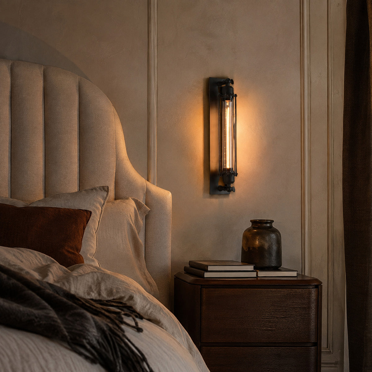 Almonda sconce beside an upholstered headboard in a master bedroom