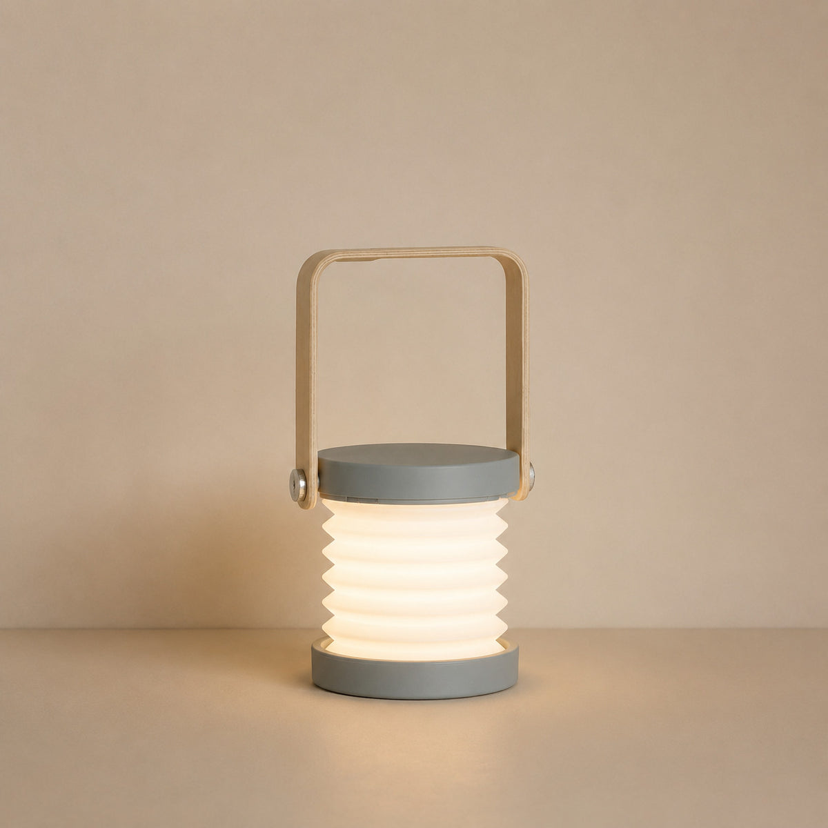 Alva collapsible portable lantern in grey, pulled open, with a bamboo swing handle