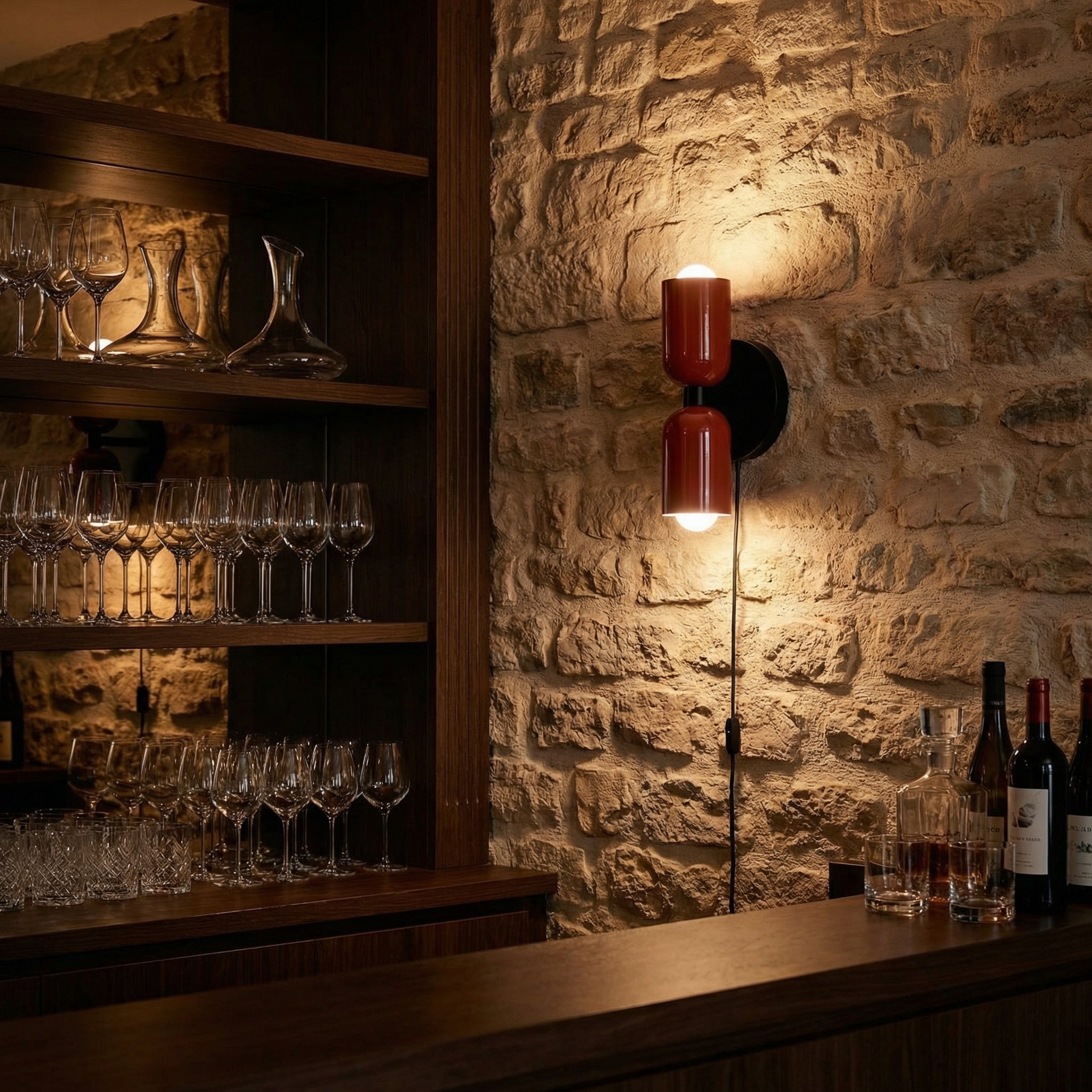 Alvor red wall sconce on a stone wall in a wine bar, lighting glasses and bottles below