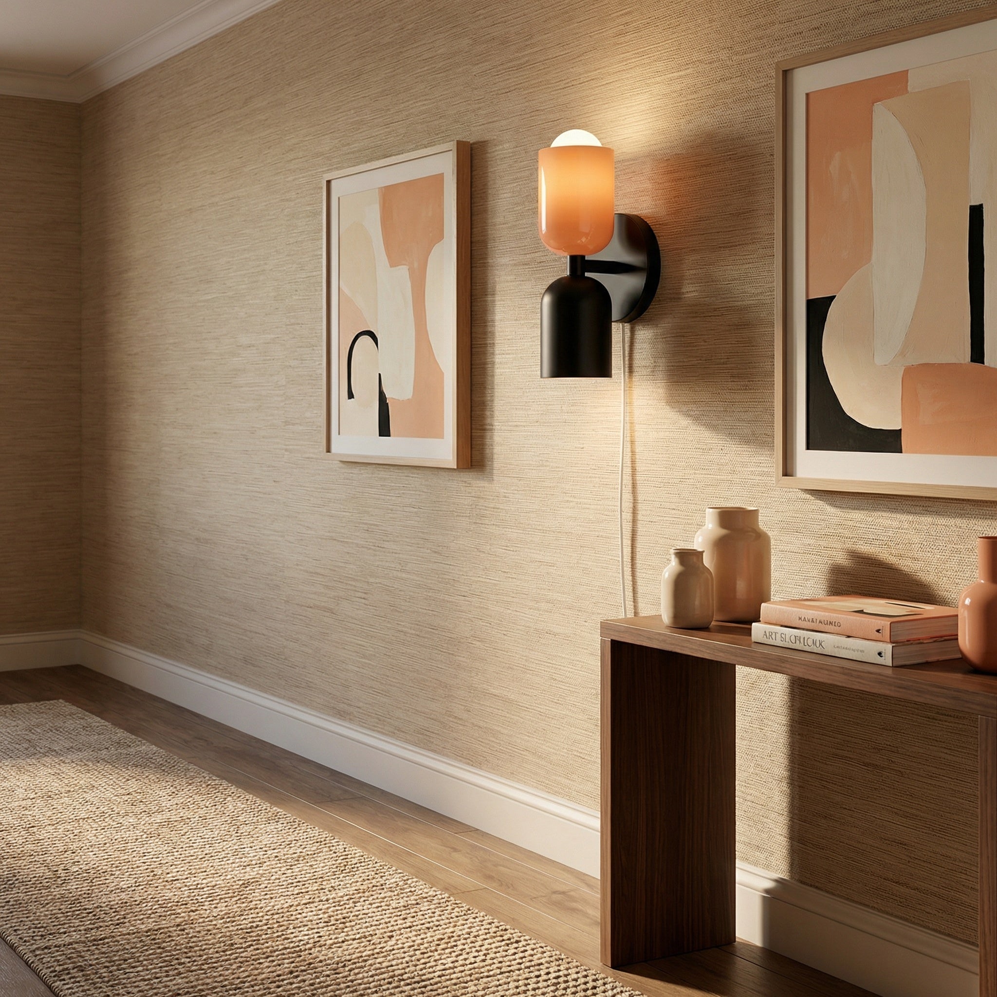 Alvor beige and black wall sconce on a grasscloth wall above a walnut console with framed prints