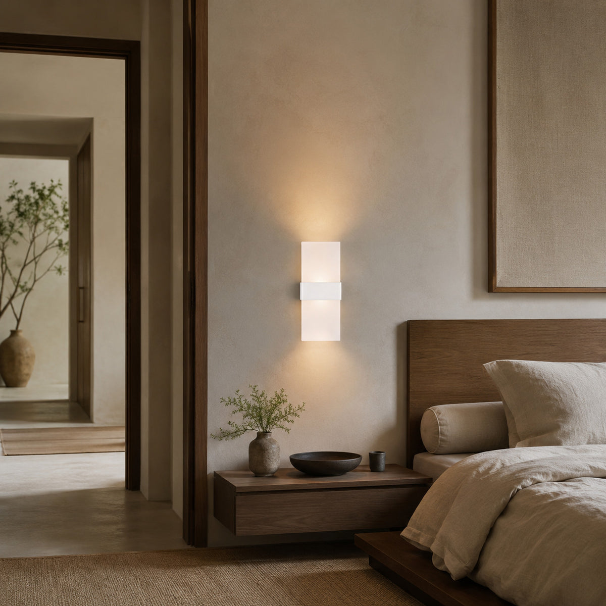Anços sconce in white with warm white light on a plaster wall in a Japandi bedroom