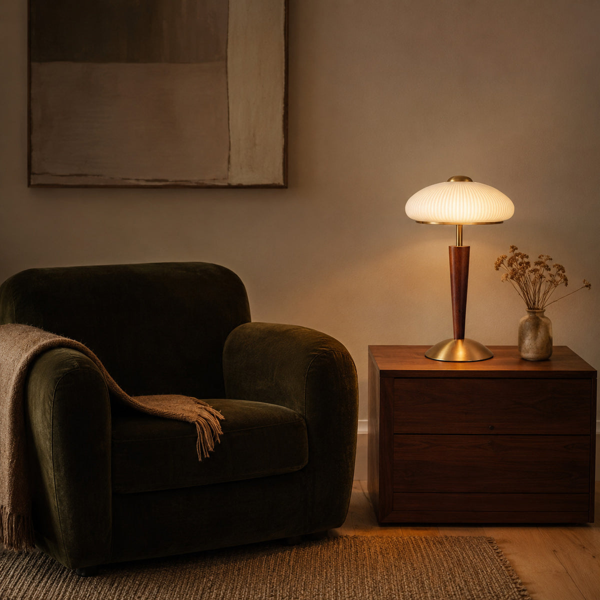 Arda fluted dome table lamp lit beside a dark green velvet armchair on a walnut side table