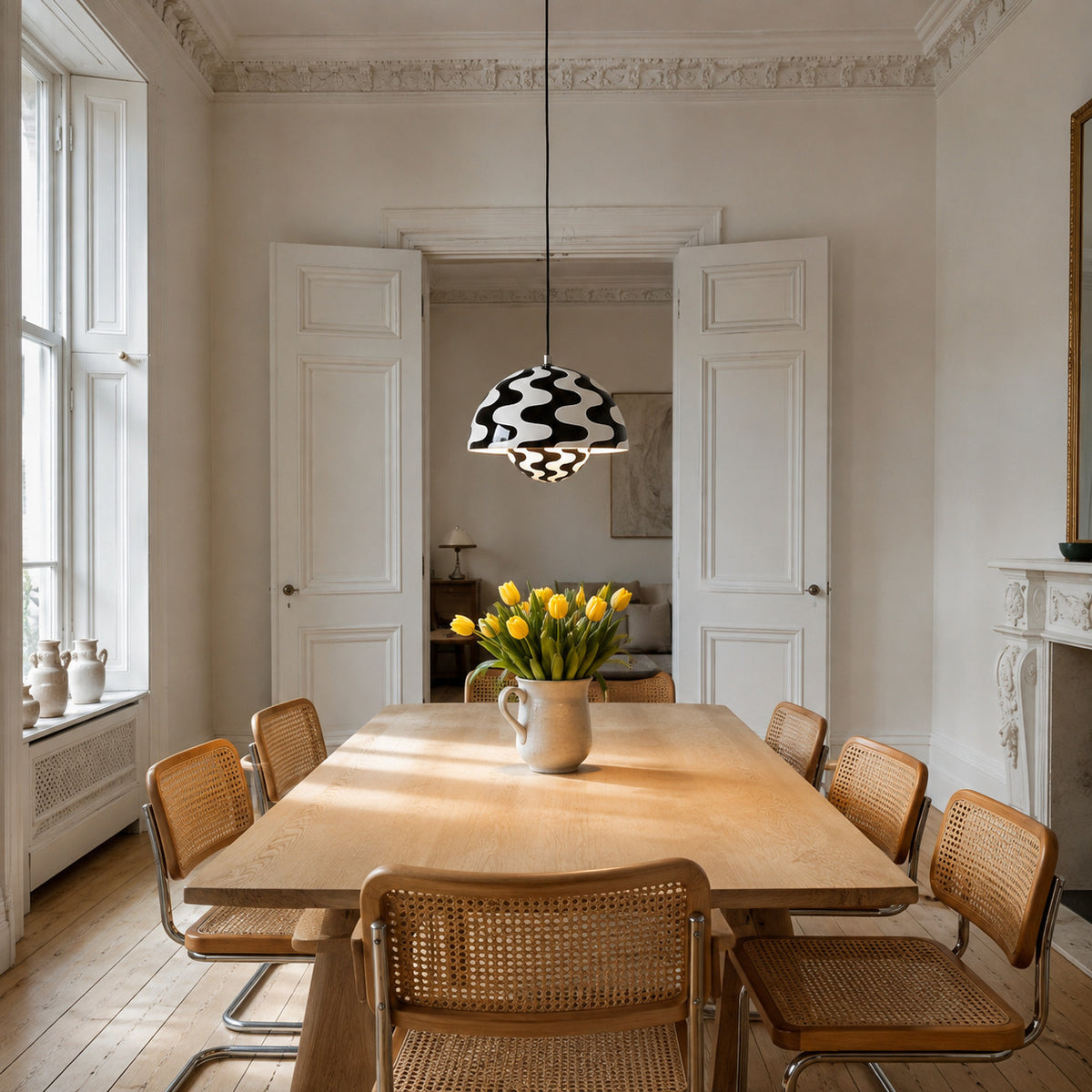 Ave hemisphere pendant in zebra color on a plain black fabric cord, 16 cm tall, shown in a room