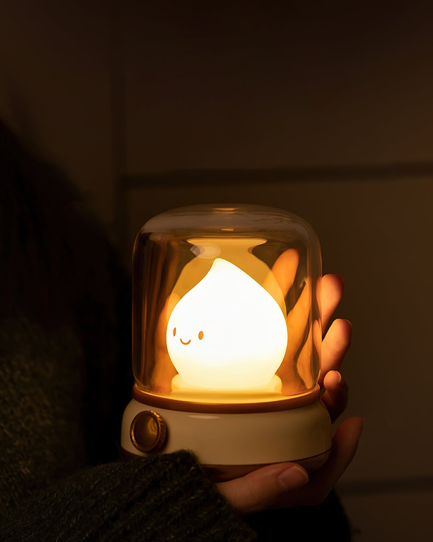 Beige flame LED night light at dusk on a windowsill.