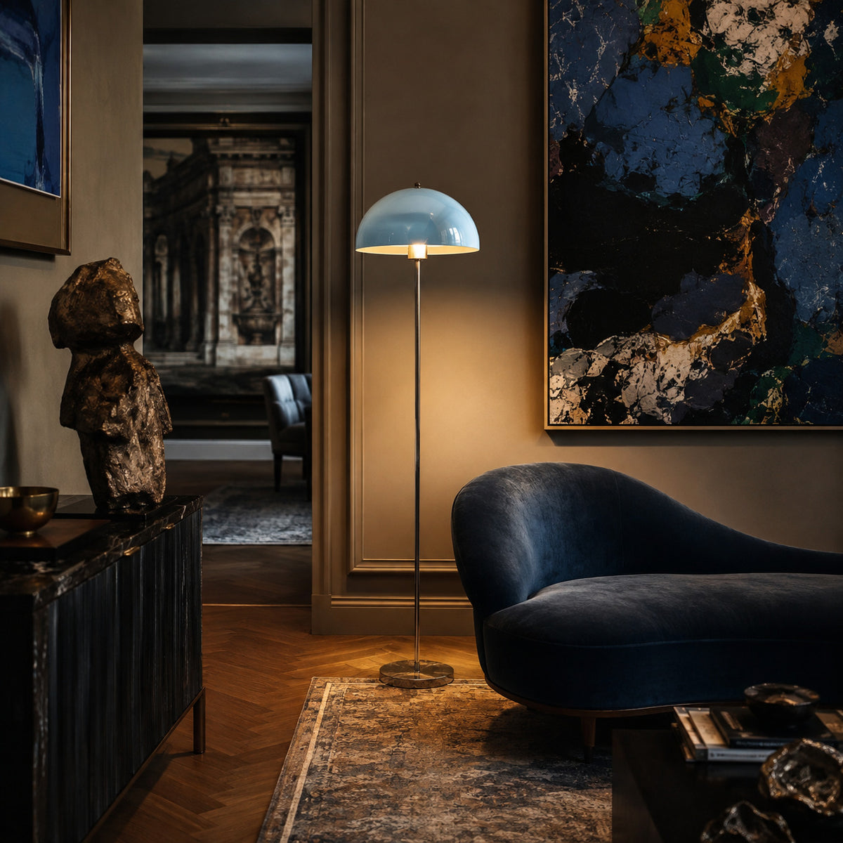 Benavente floor lamp with a sky-blue inner dome, lit in a dark gallery room beside artwork