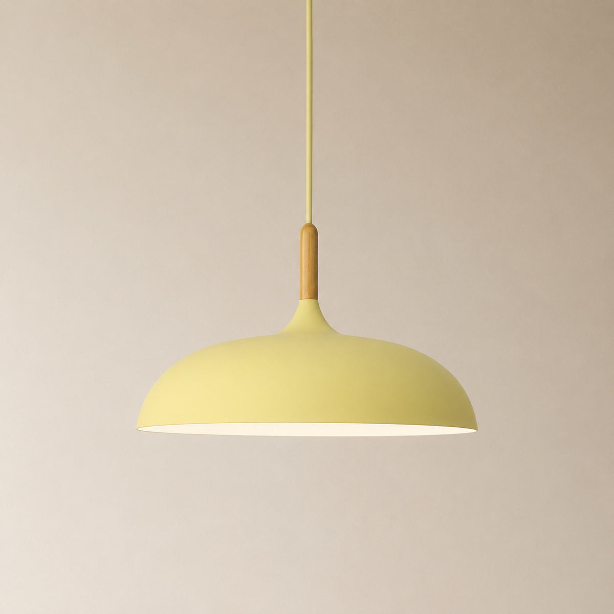 Cobres pendant in pale pastel yellow with a turned wood cap, the wide shallow Flat Sphere shade
