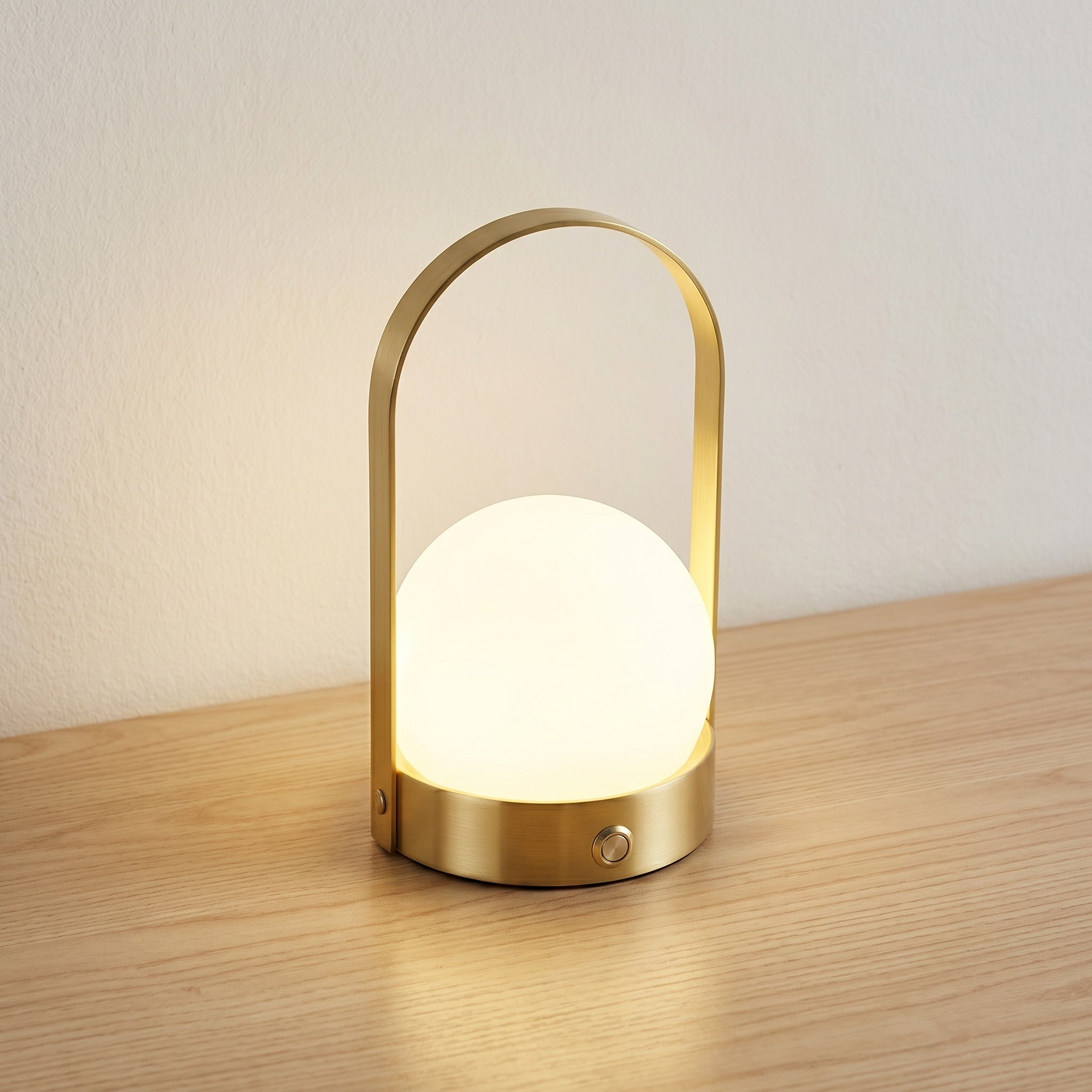 Cordless touch table lamp with gold metal basket-base and white glass orb, product shot.