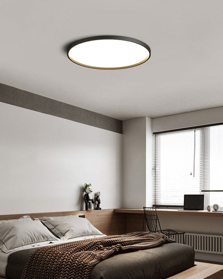Estorãos flat round flush mount ceiling light, in a bedroom, above the bed.