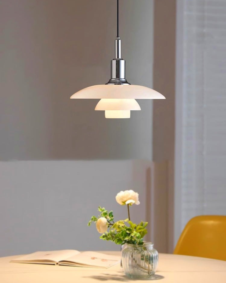 Fundão round ceiling light, in a dining room, beside a yellow chair.
