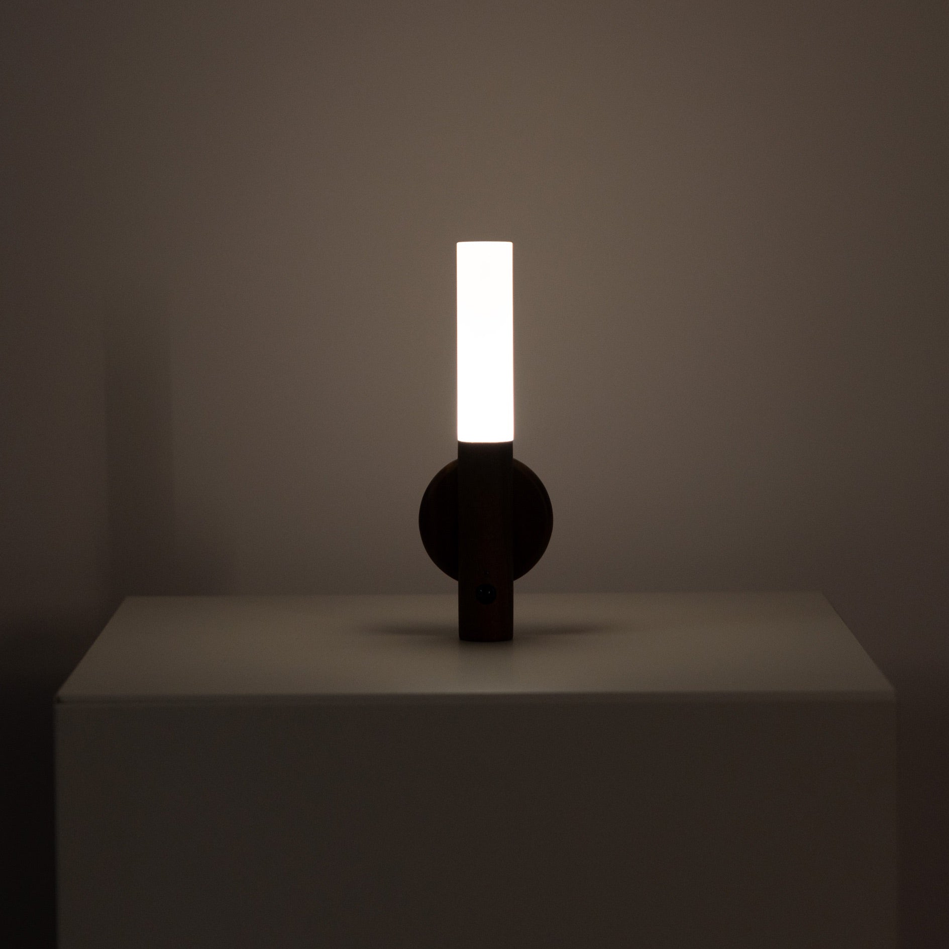 Manteigas wood sconce on its magnetic wall base with the motion sensor facing forward
