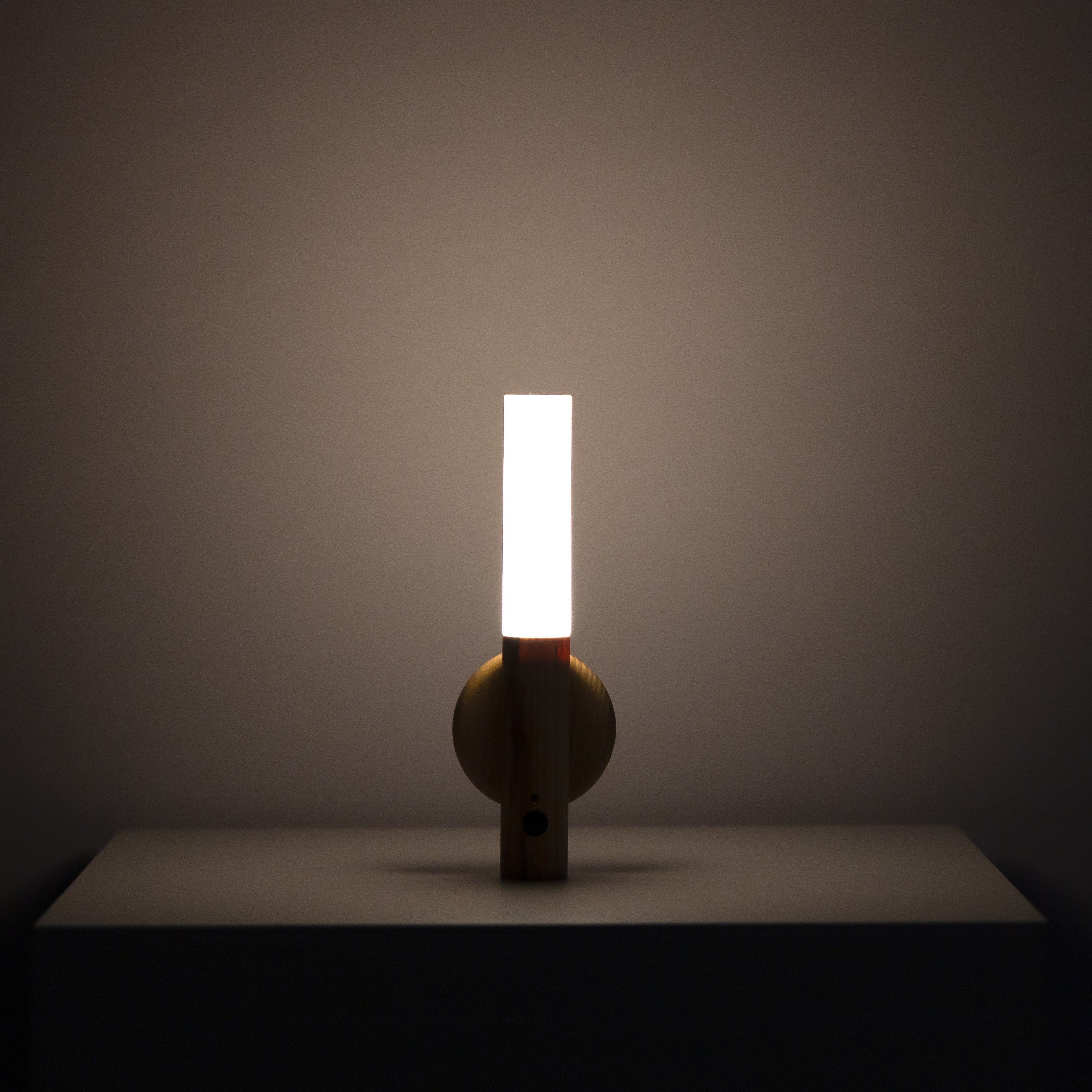 Manteigas wall sconce close-up showing the solid-wood grain finish and slim profile