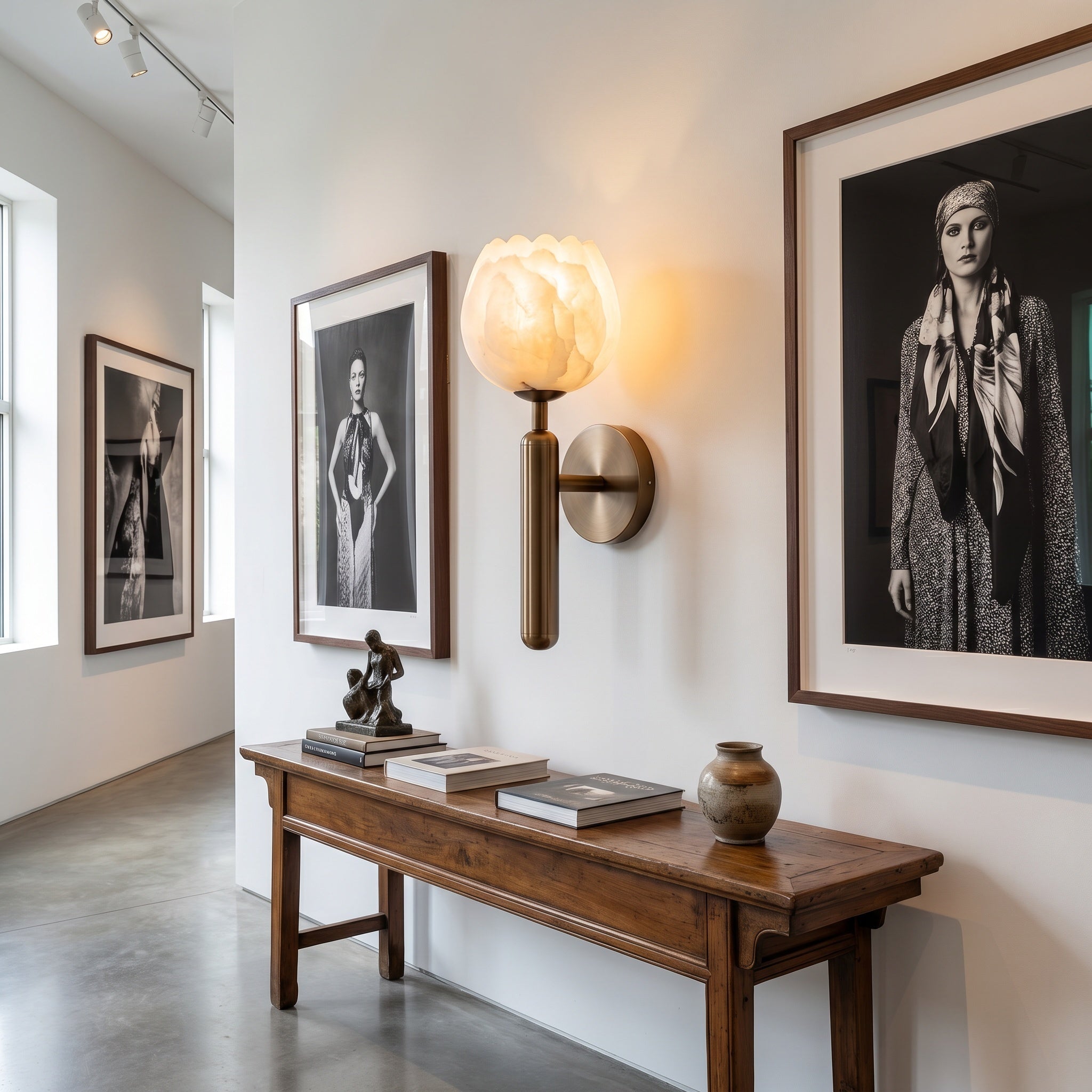 Mértola black-finish sconce on a living room wall, warm glow over a seating nook