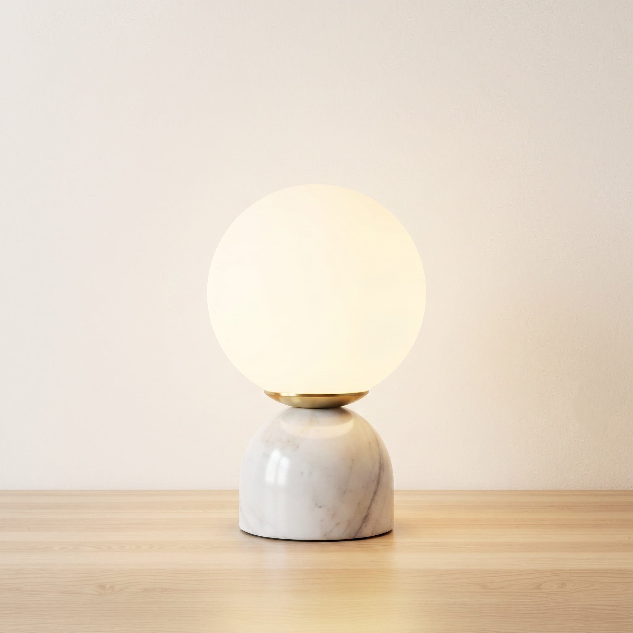 Marble table lamp with white veined base and frosted glass orb, product shot.