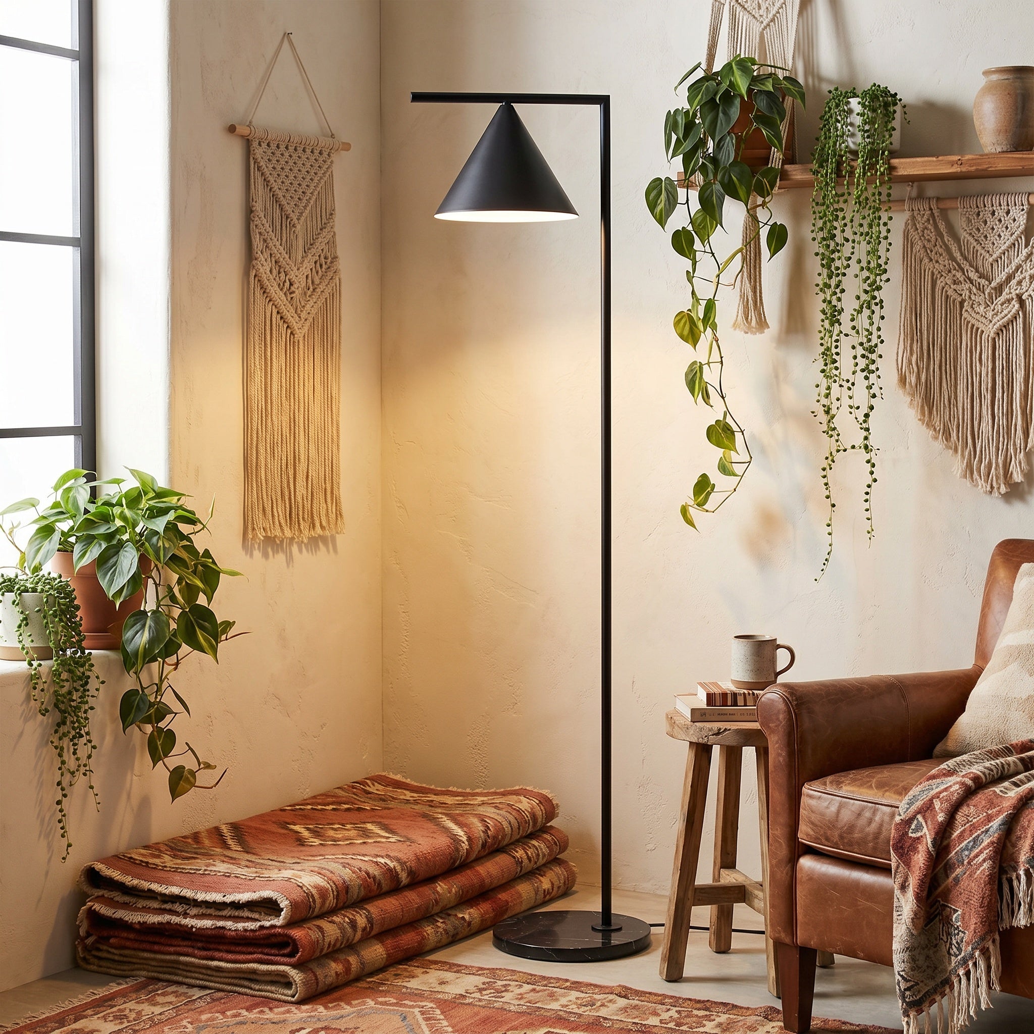 Black cone floor lamp in a boho room with macrame, plants, and a leather chair.