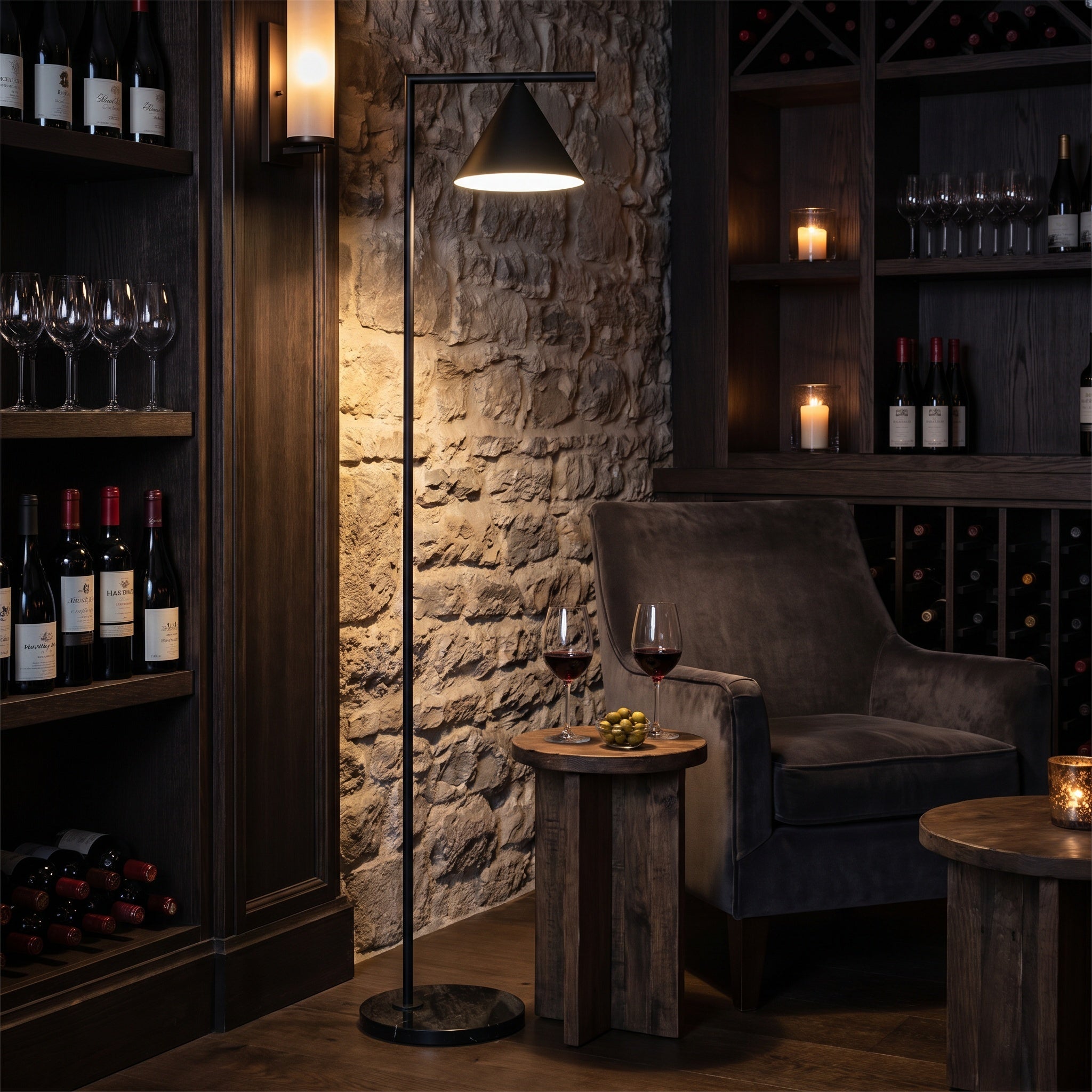 Black cone floor lamp in a stone-walled wine cellar with a leather chair.