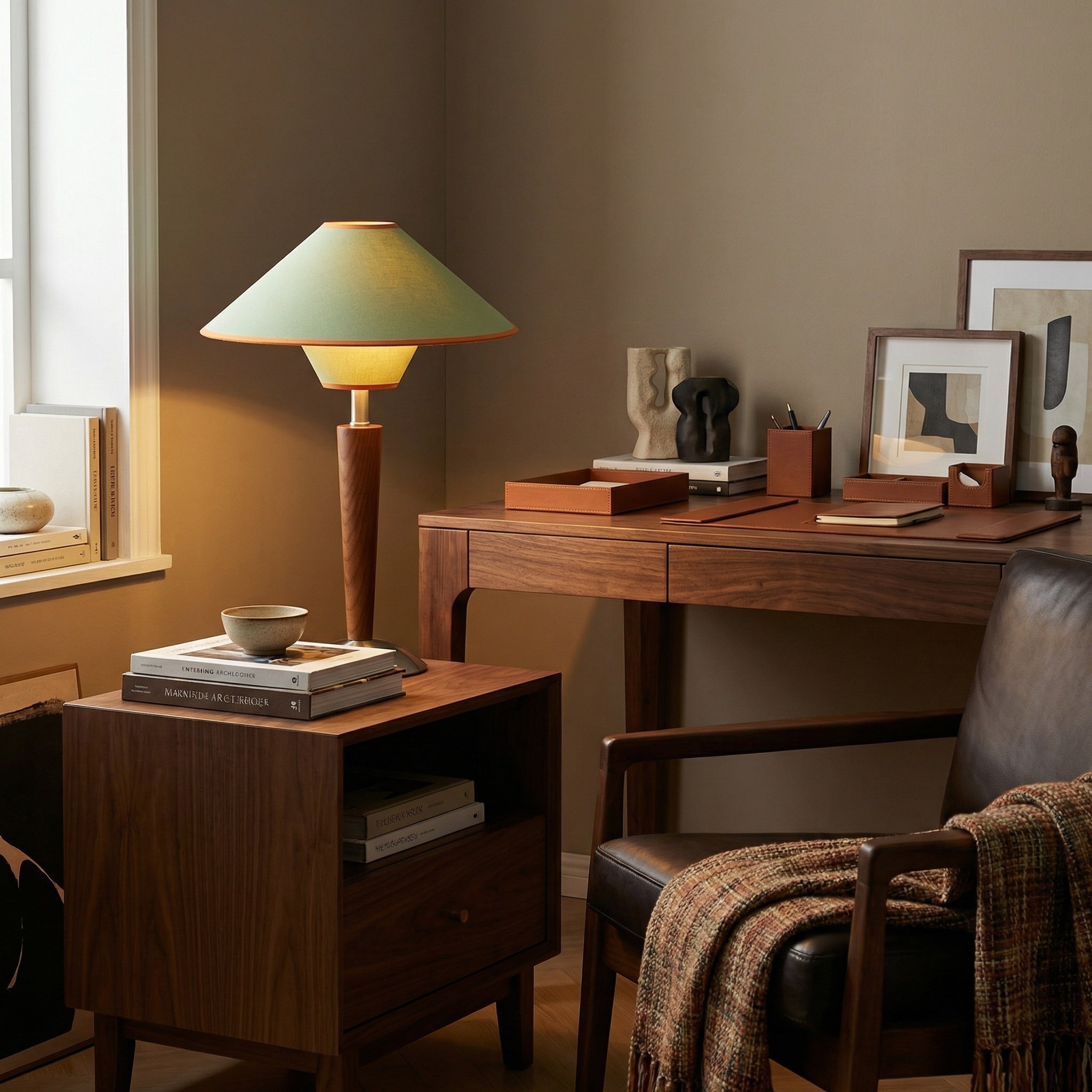 Walnut wooden table lamp with green shade on a walnut desk in a study.