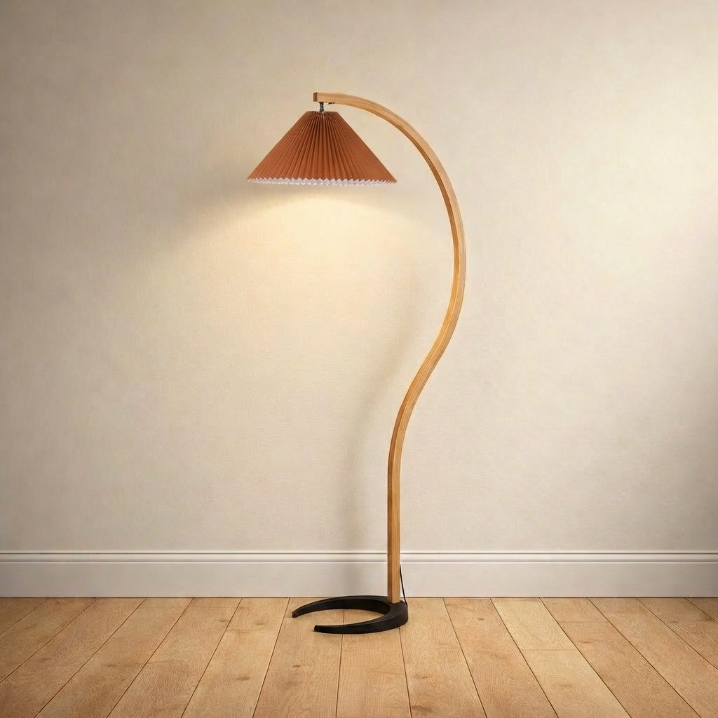 Bentwood beech floor lamp with a pleated coffee linen shade on a plain wall over wood floors.